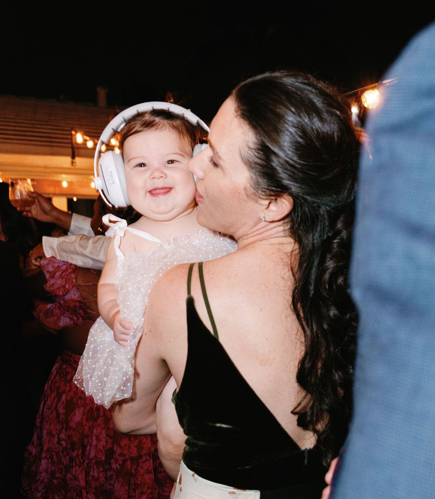 Candid moments at a wedding reception showing joyful interactions with a baby in white dress.
