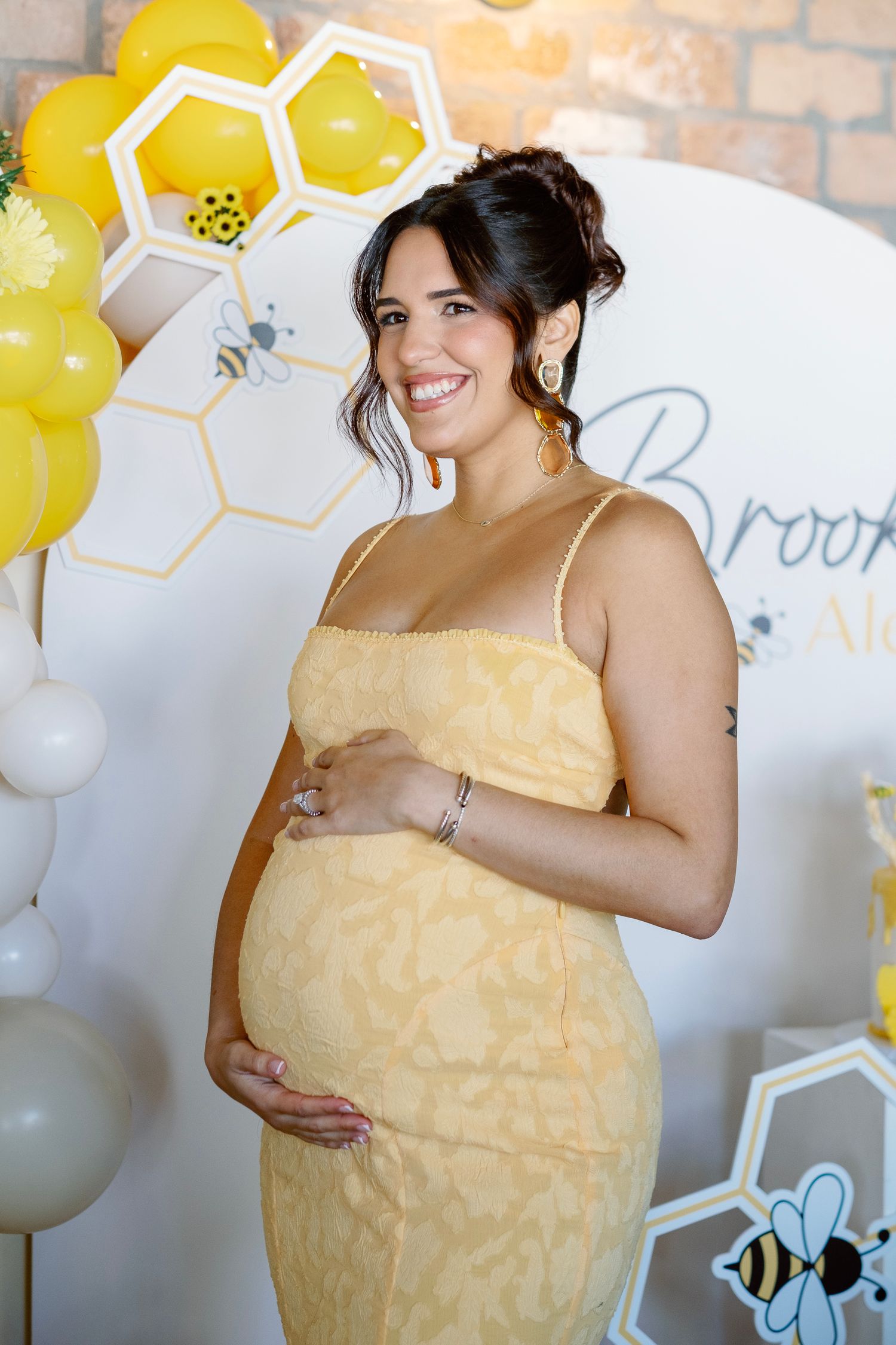 A yellow dress is showcased against a backdrop of yellow balloons and festive party decorations.