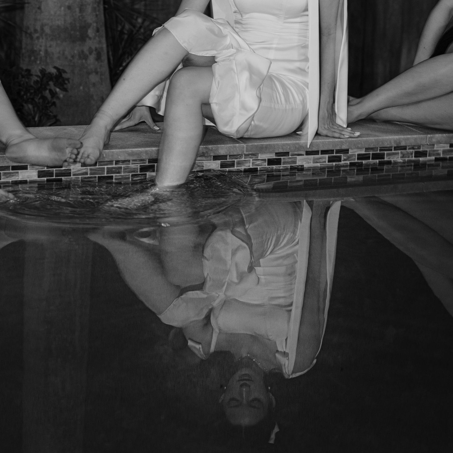 Black and white photo series showing reflections of a couple's feet in water.