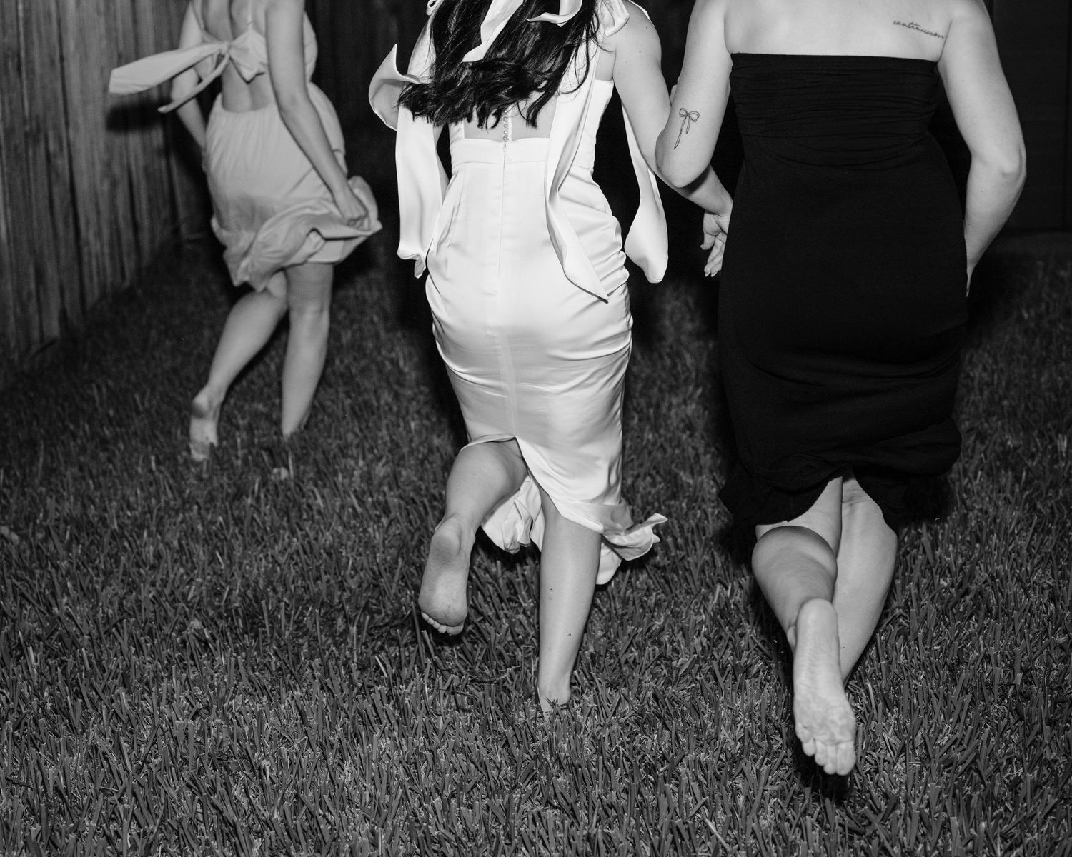 Black and white sequence of dancing movements on grass against wooden fence.