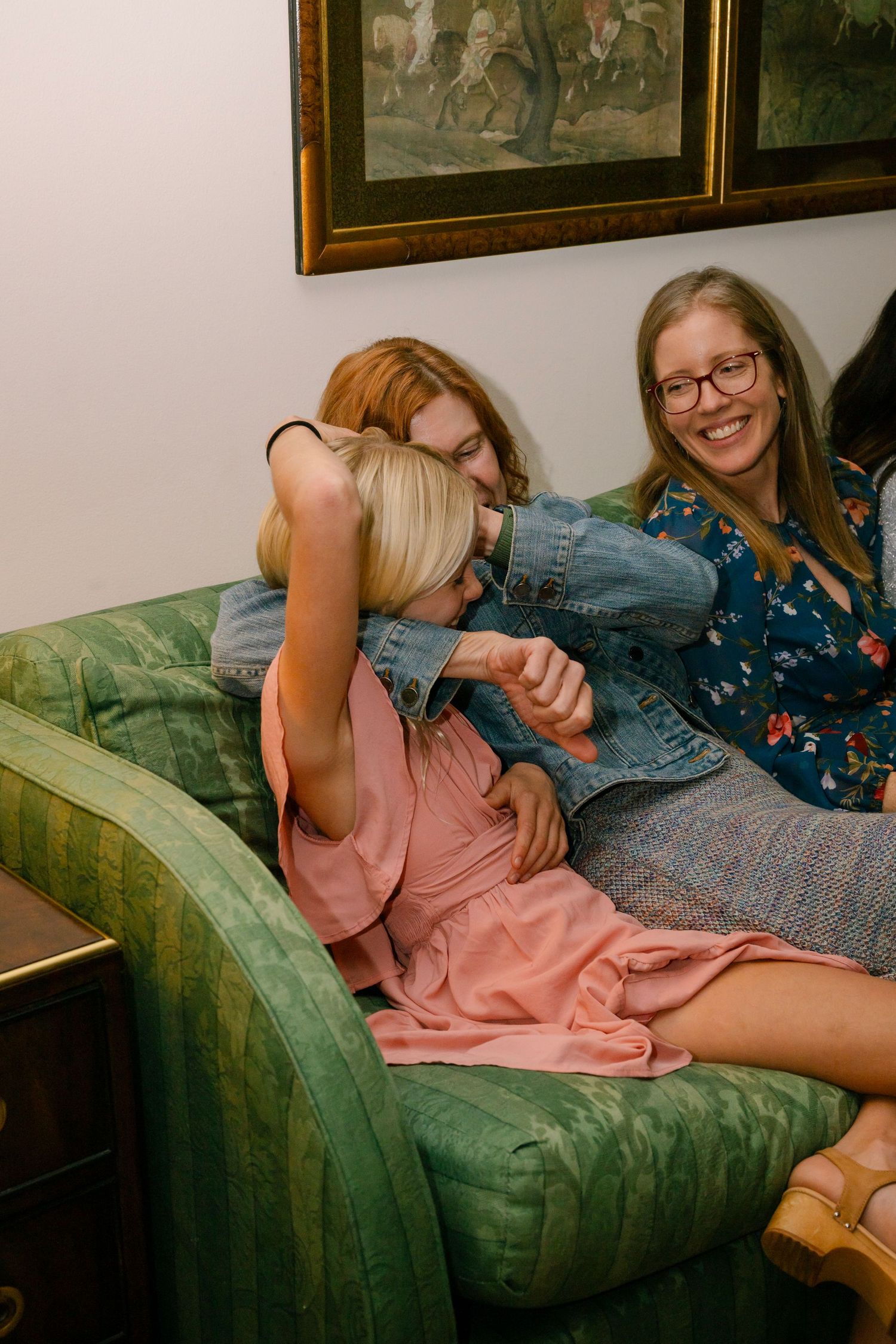 Four sequential photos showing friends laughing and having fun while lounging on a vintage green velvet couch.