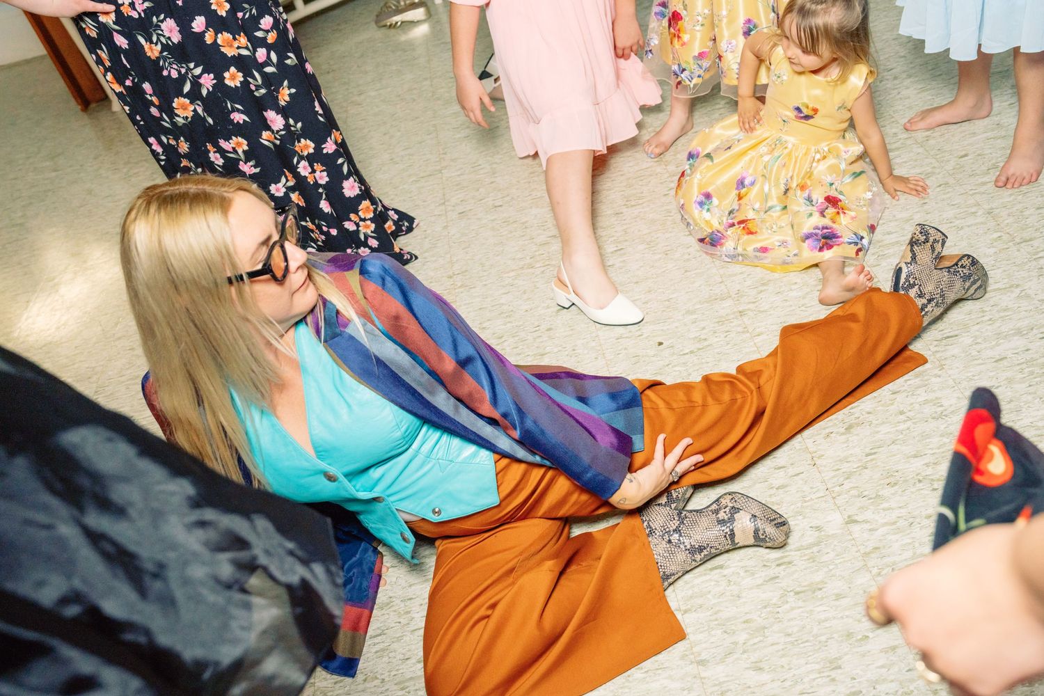 Guests in colorful dresses dancing and celebrating at an indoor party.