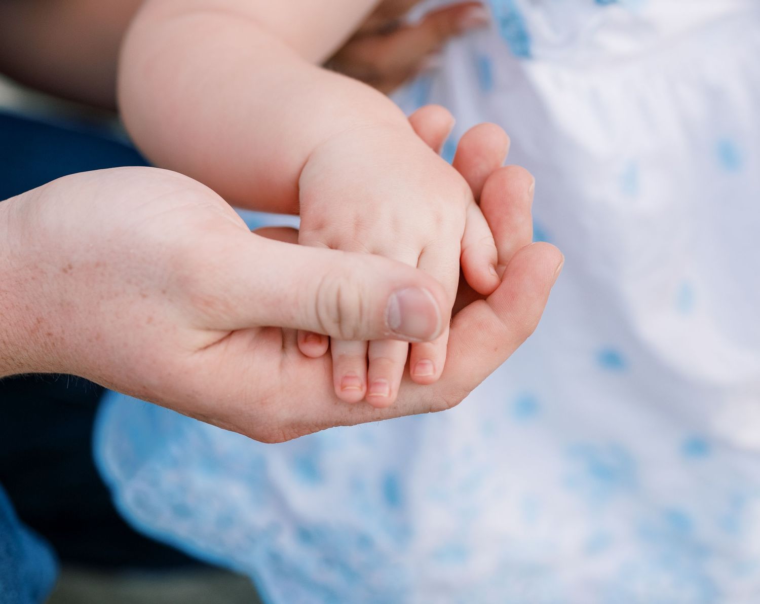 Close-up shots of hands gently touching against a soft blue background.