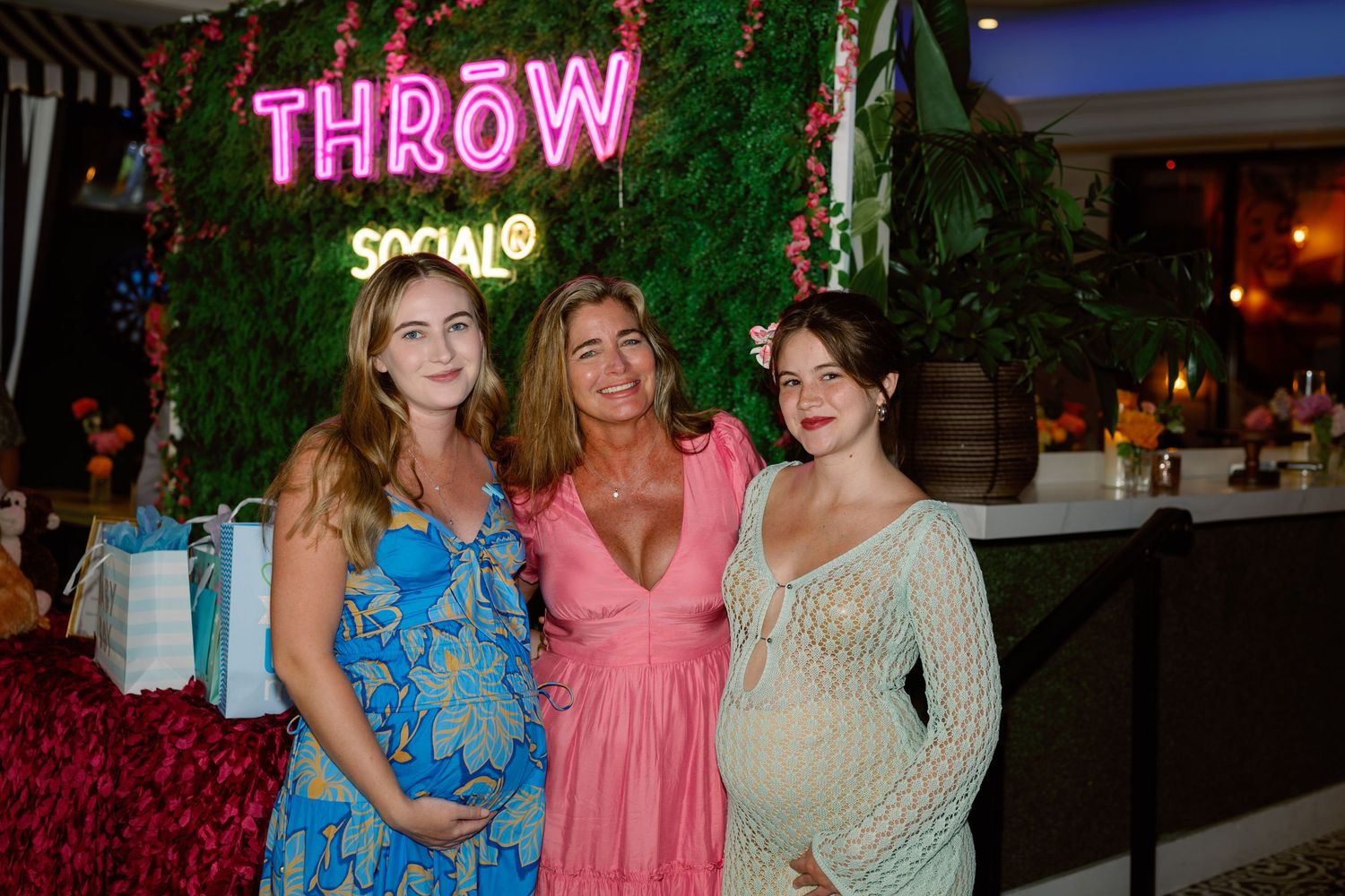 Group wearing colorful dresses gathered at a social event in an outdoor setting during evening hours.