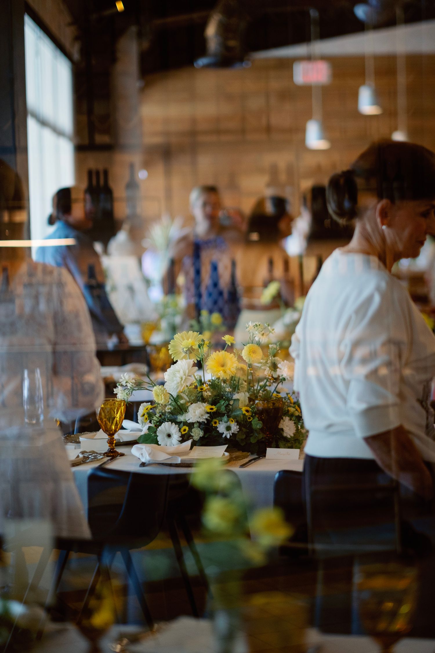 An elegant table setting with yellow floral centerpieces and ambient lighting.