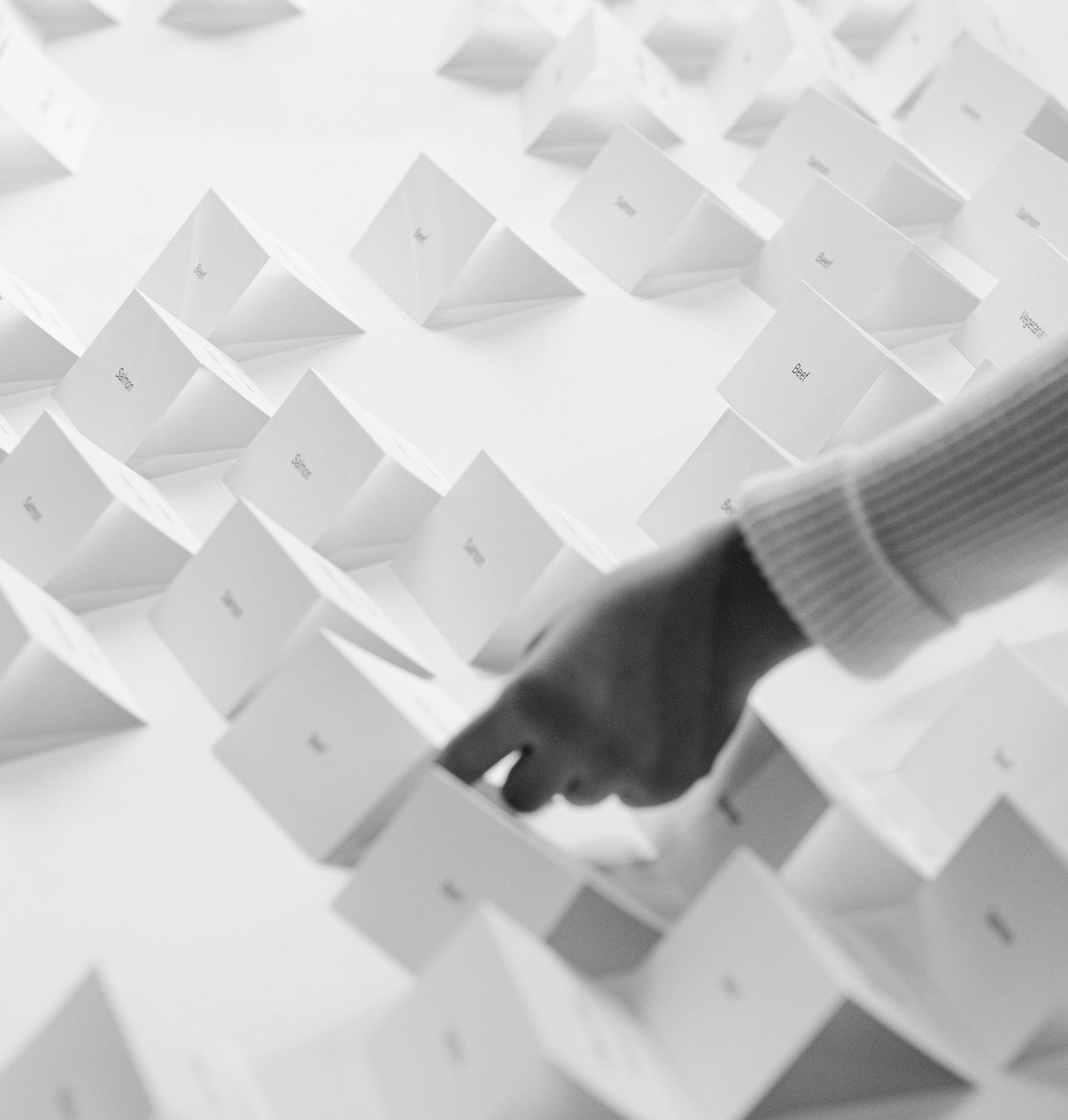 White paper airplanes arranged in a neat geometric pattern on a light background create an abstract composition.