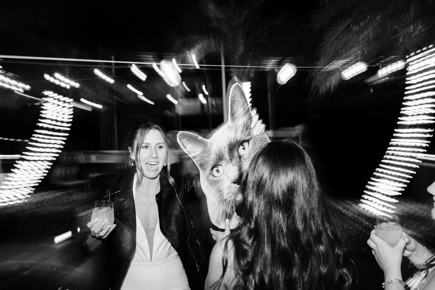 Black and white photo of people dancing at a nightclub with streaking lights creating dramatic motion effects.