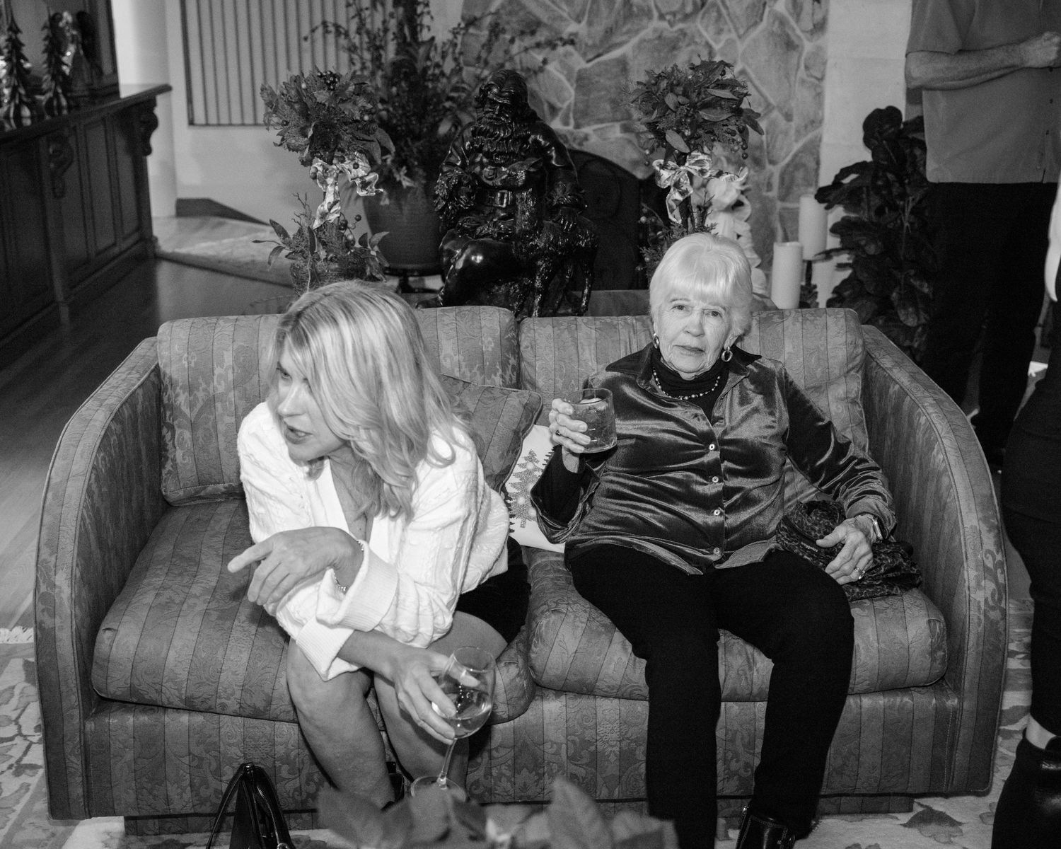 A black and white photo collage shows people sitting on couches in what appears to be a living room setting.