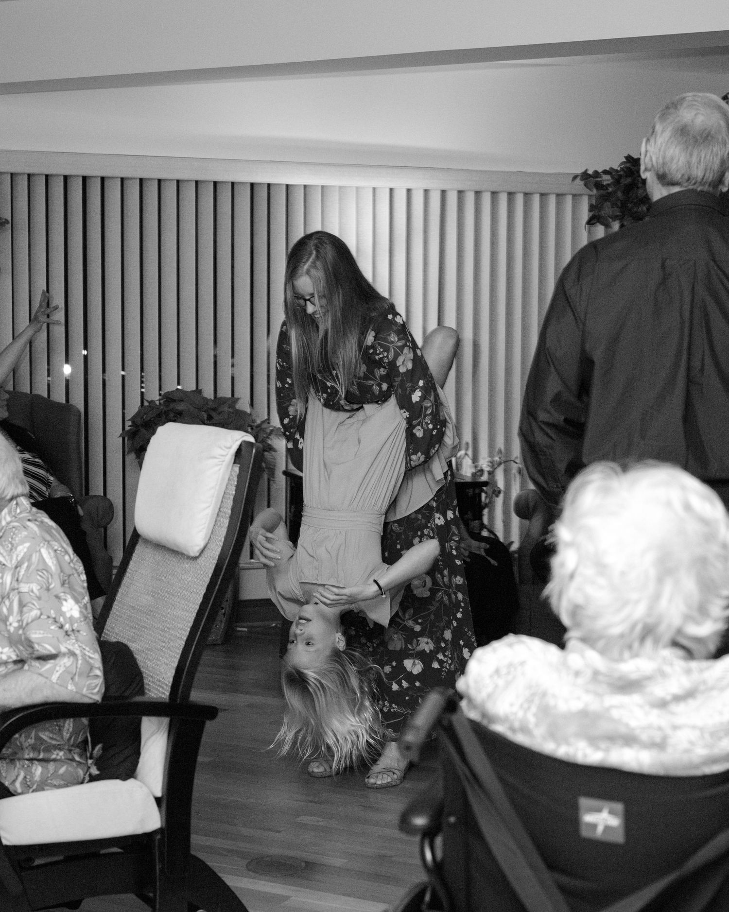 Black and white sequence of people moving and interacting in an indoor space with striped walls.