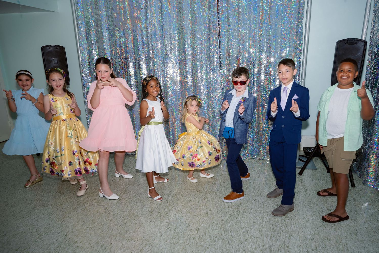 Wedding party members' legs and feet shown against a sparkly silver backdrop.