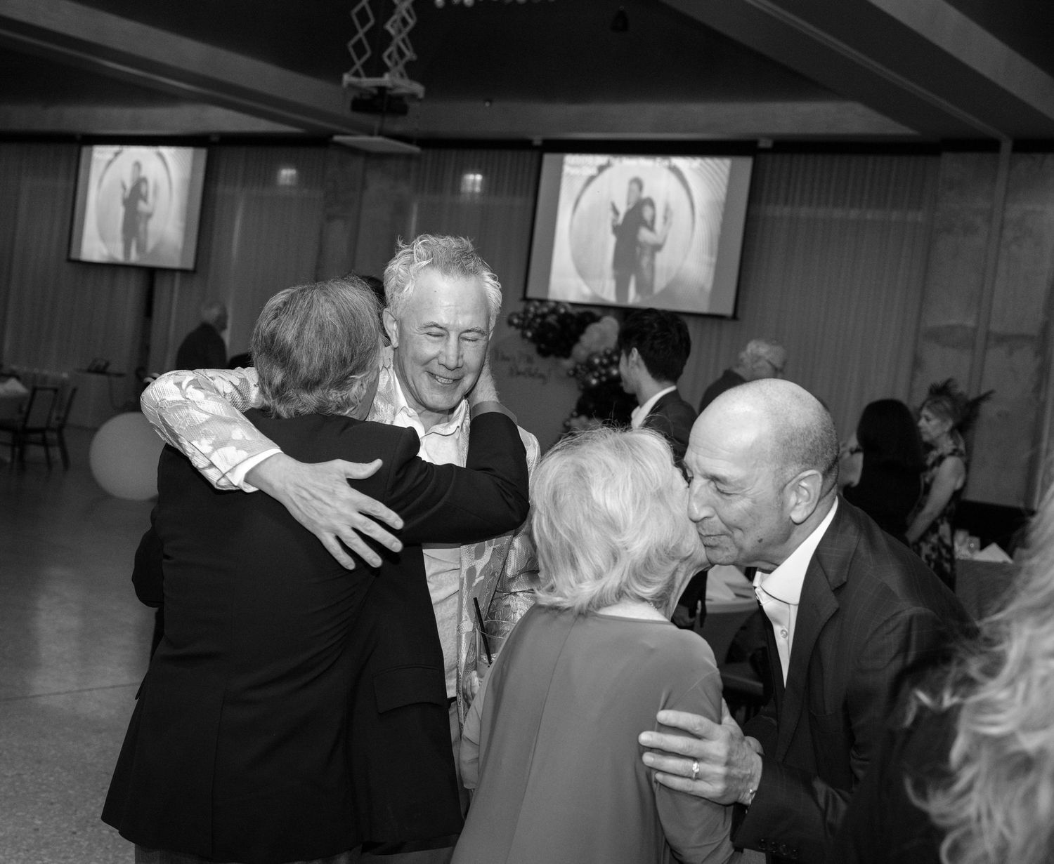 A series of black and white photos showing people dancing and embracing at what appears to be a social gathering.