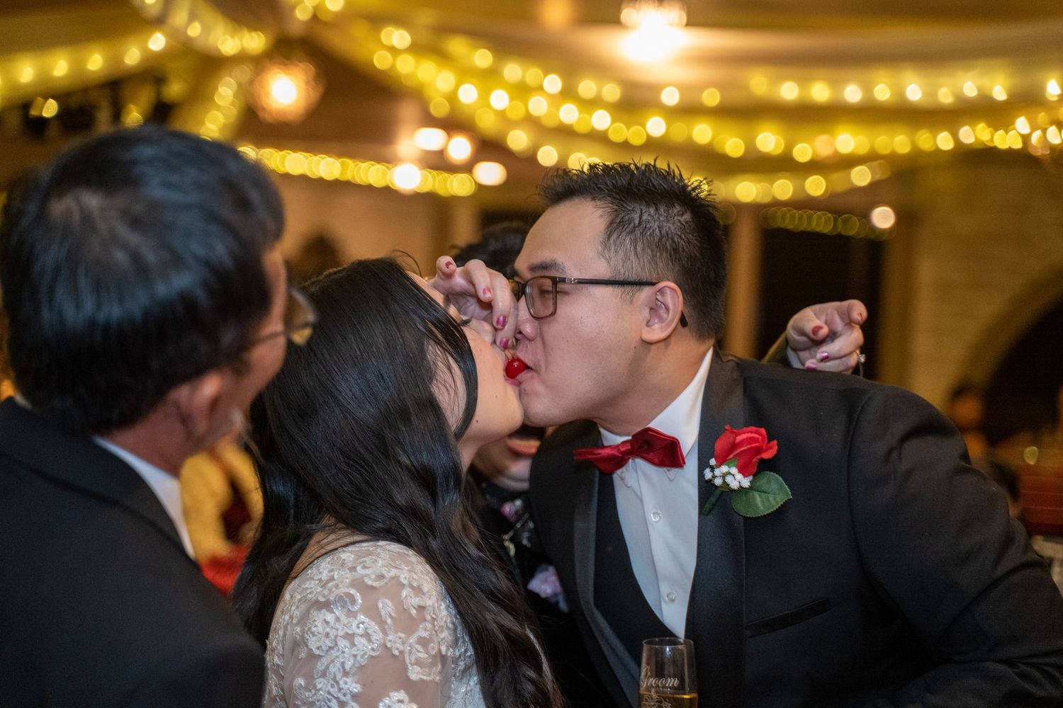 Bride and groom sharing a sweet cherry kiss at The Buttes at Reflections wedding venue in Tucson, AZ, by N&D Media Production.