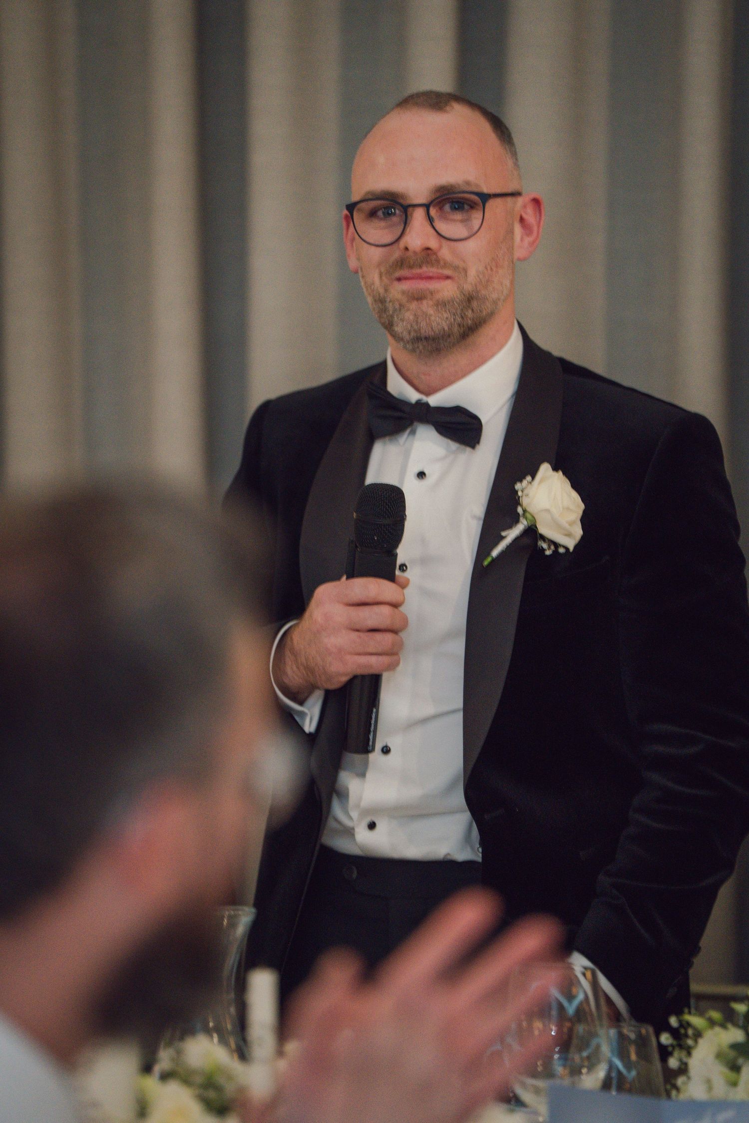 Groom in black tuxedo with bow tie and boutonniere delivering speech at wedding reception at Mount Juliet wedding in Kilkenny.