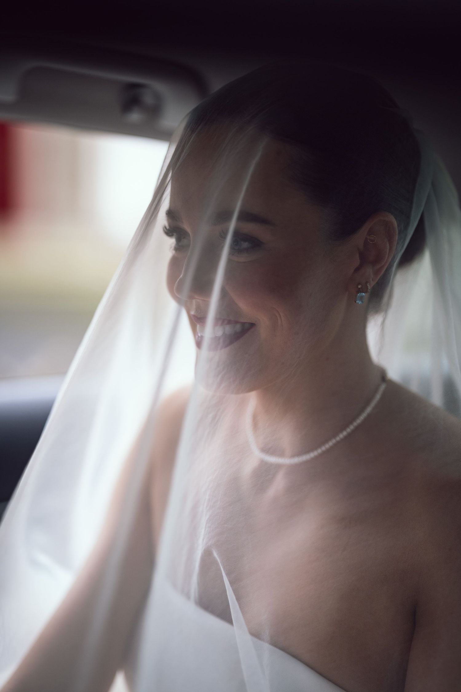 Radiant bride wearing veil and pearl necklace smiles softly at Bellinter House wedding in Co. Meath.