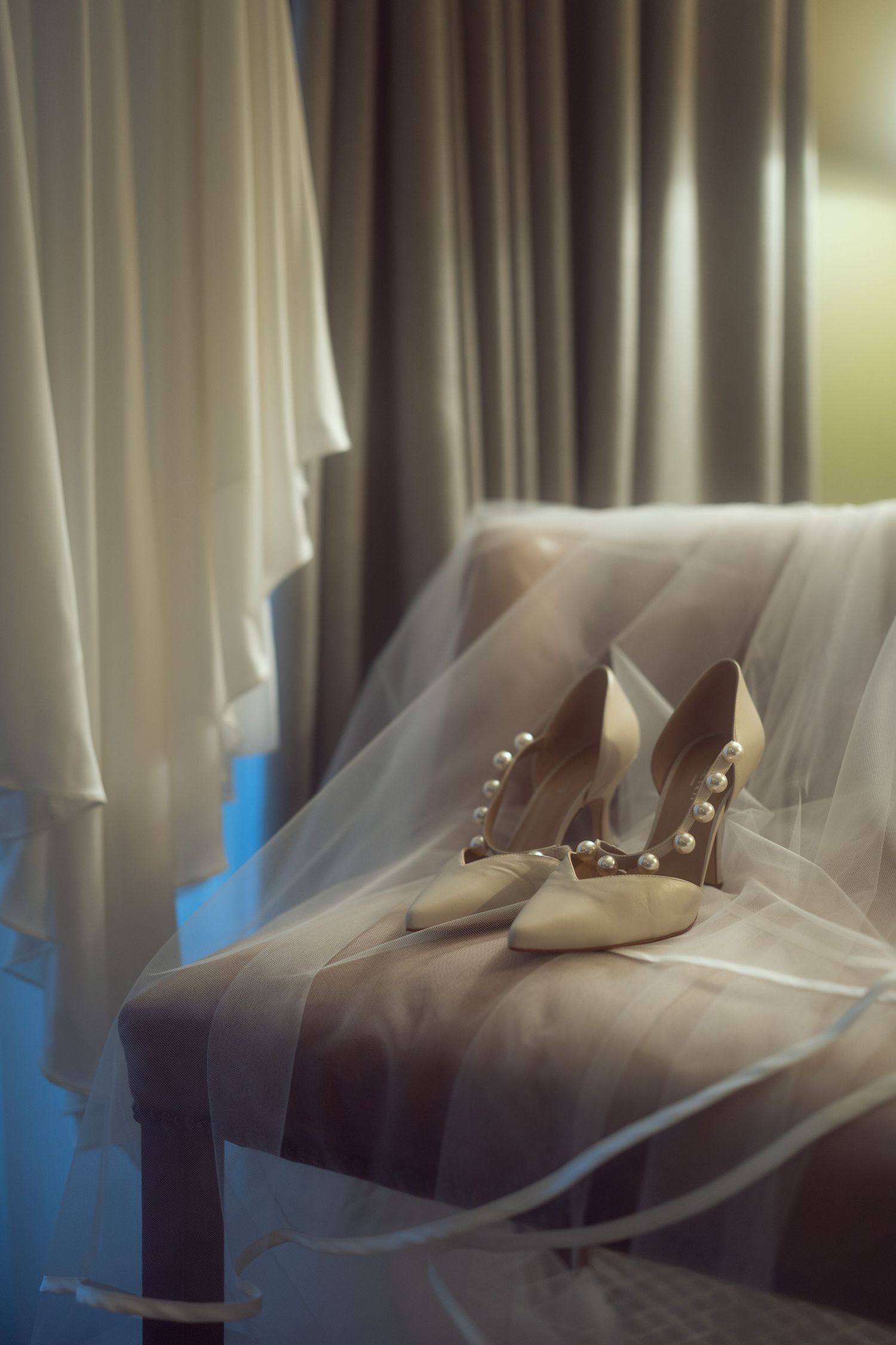 Pearl-embellished bridal heels resting on a chair with a flowing veil nearby at the Manor House Mount Juliet wedding Kilkenny.