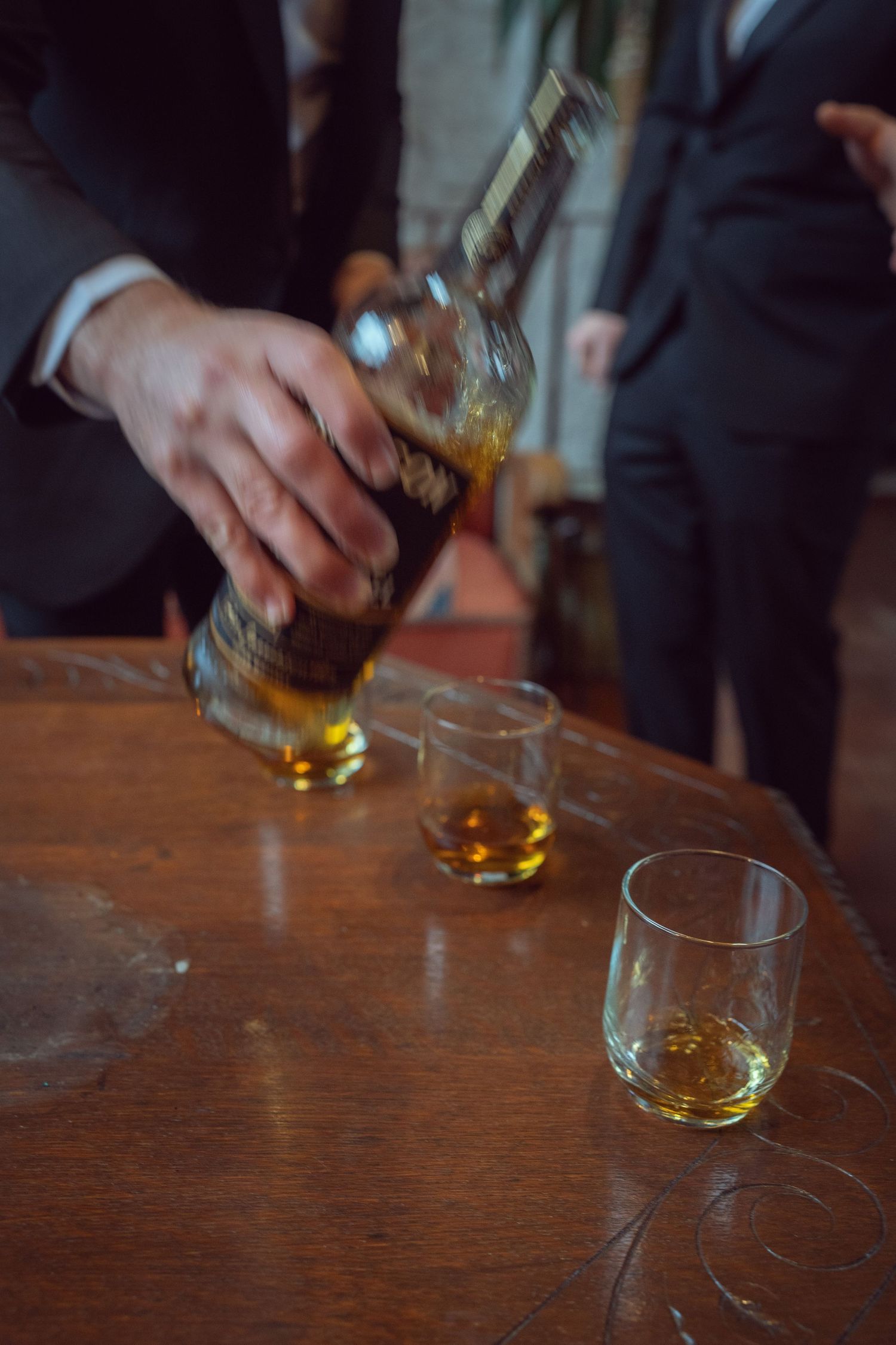 Groomsman pouring whiskey into glasses at the Manor House Mount Juliet wedding Kilkenny.