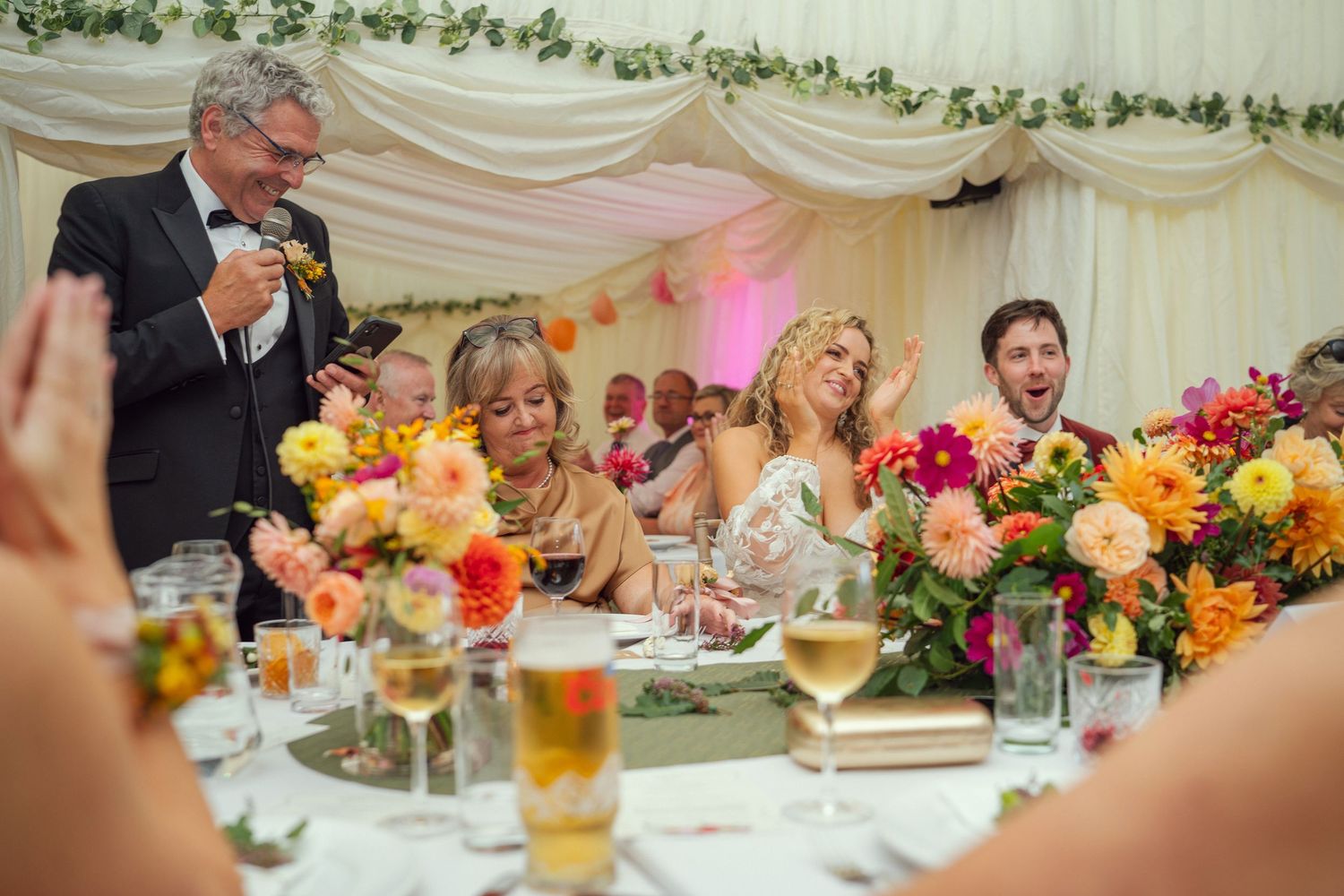 Father of the bride delivers a heartfelt speech at a colorful wedding reception at outdoor garden wedding reception in Co Meath.