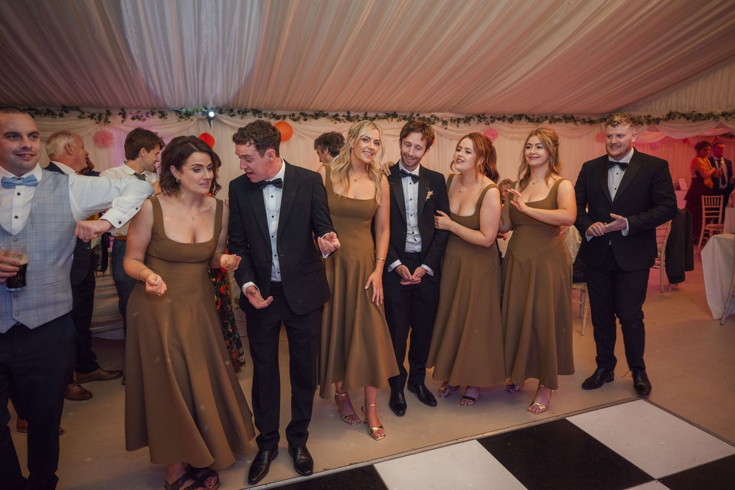 Bridesmaids with groomsmen on dance floor at a wedding at outdoor garden wedding reception in Co Meath.