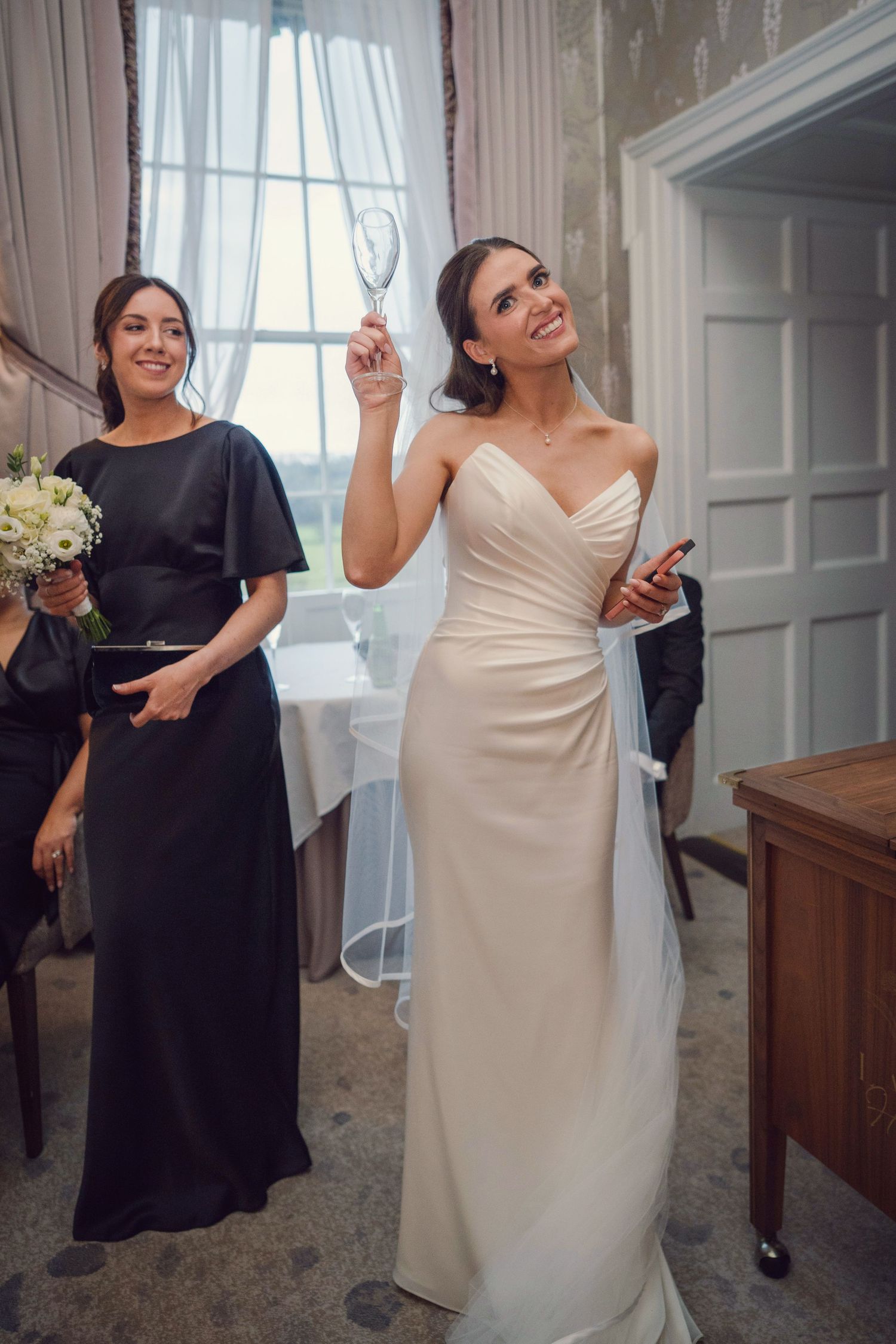Radiant bride in ivory gown raises champagne glass at the Manor House Mount Juliet wedding Kilkenny.