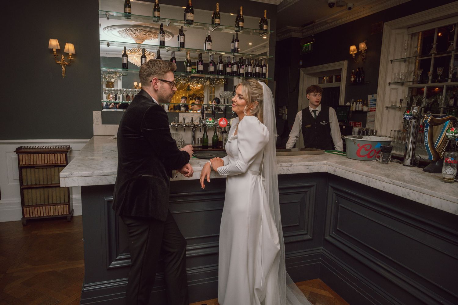 Bride and groom share a romantic moment at an elegant bar during their wedding reception.
