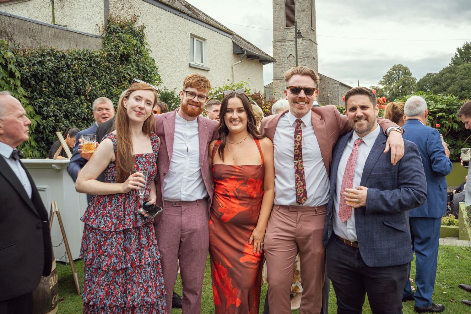Wedding guests posing and smiling together in a outdoor garden wedding reception in Co Meath.