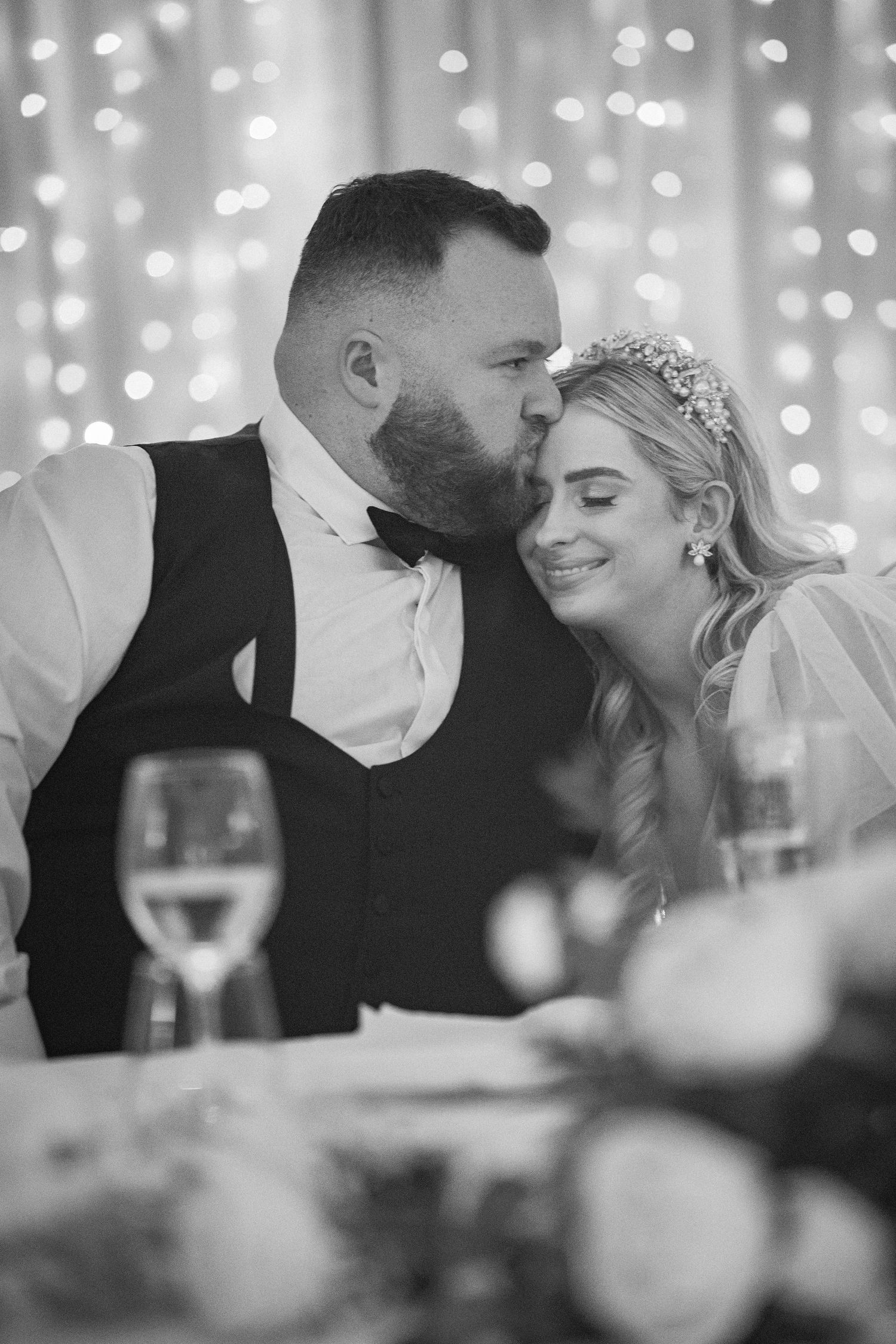 Groom kissing bride on cheek at wedding reception at The Hodson Bay Hotel in Athlone, Co. Roscommon.