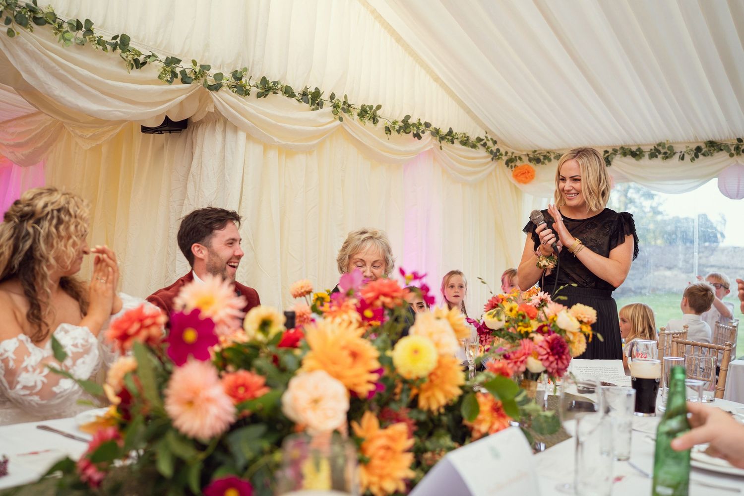 Wedding guest giving speech at decorated reception table outdoor garden wedding reception in Co Meath.