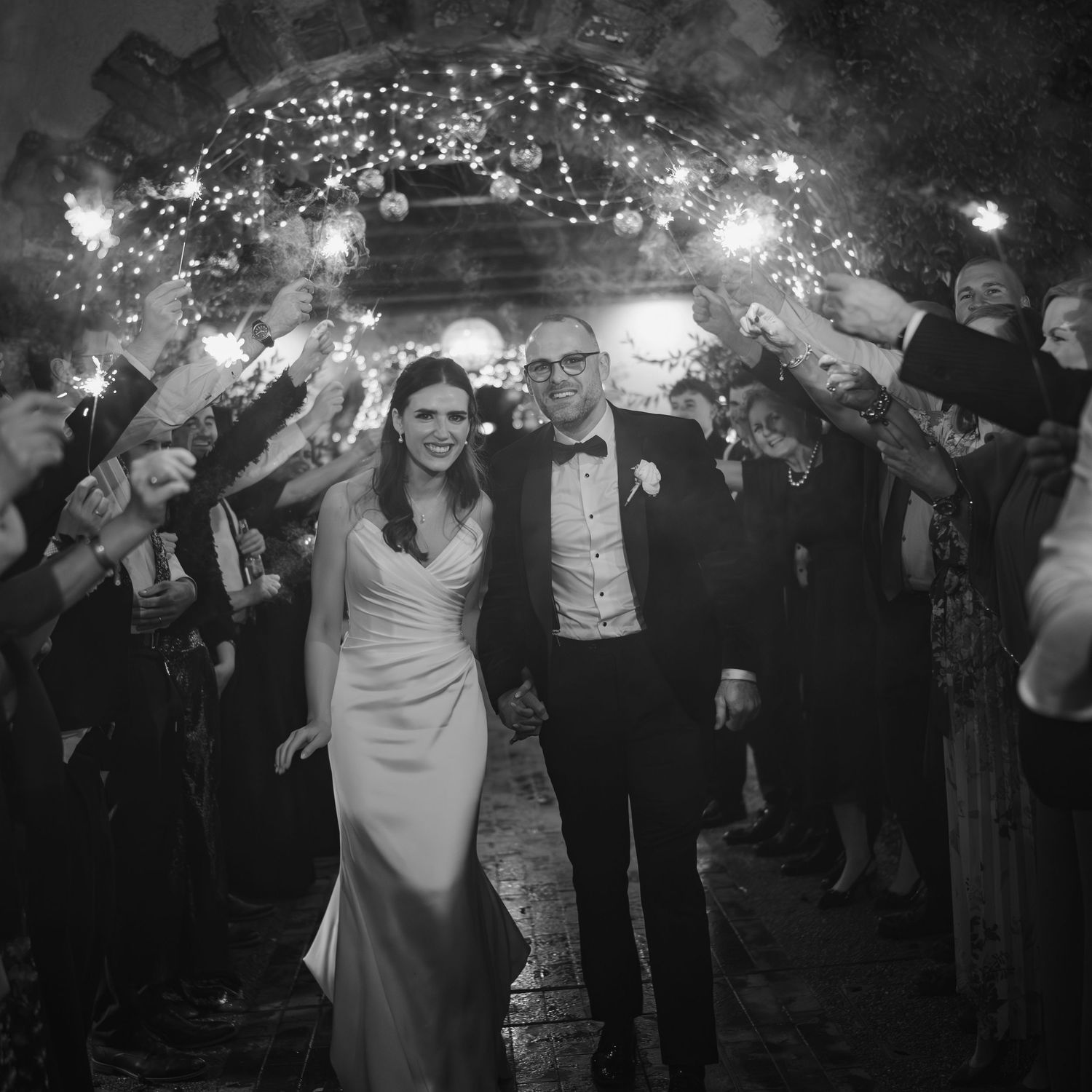 Bride and groom walking through sparkler tunnel exit at their elegant evening wedding reception at Mount Juliet wedding in Kilkenny.