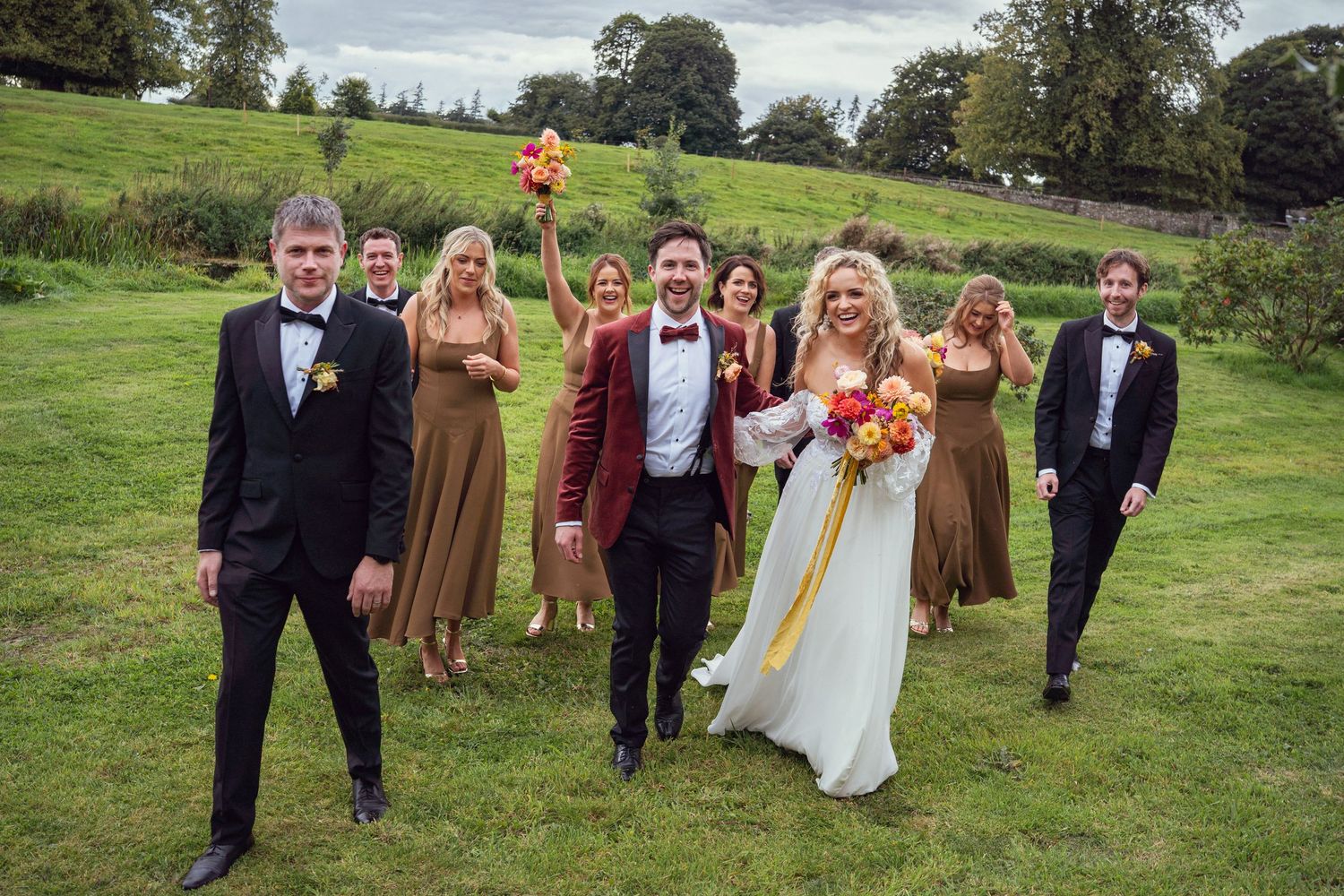 Wedding party walking on grass outdoor garden wedding reception in Co Meath.