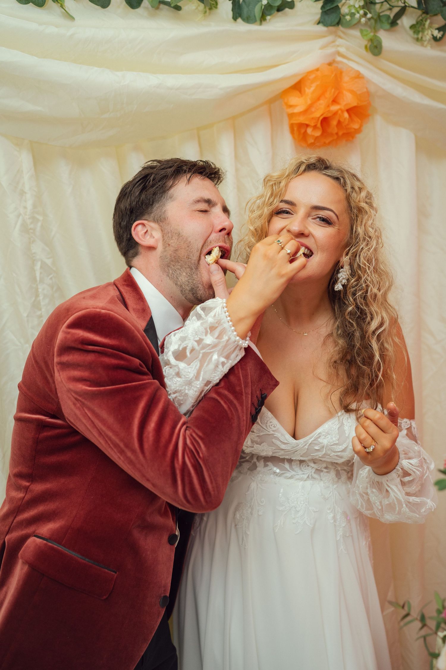 Bride and groom playfully feeding each other wedding cake at their wedding reception at outdoor garden wedding in Co Meath.