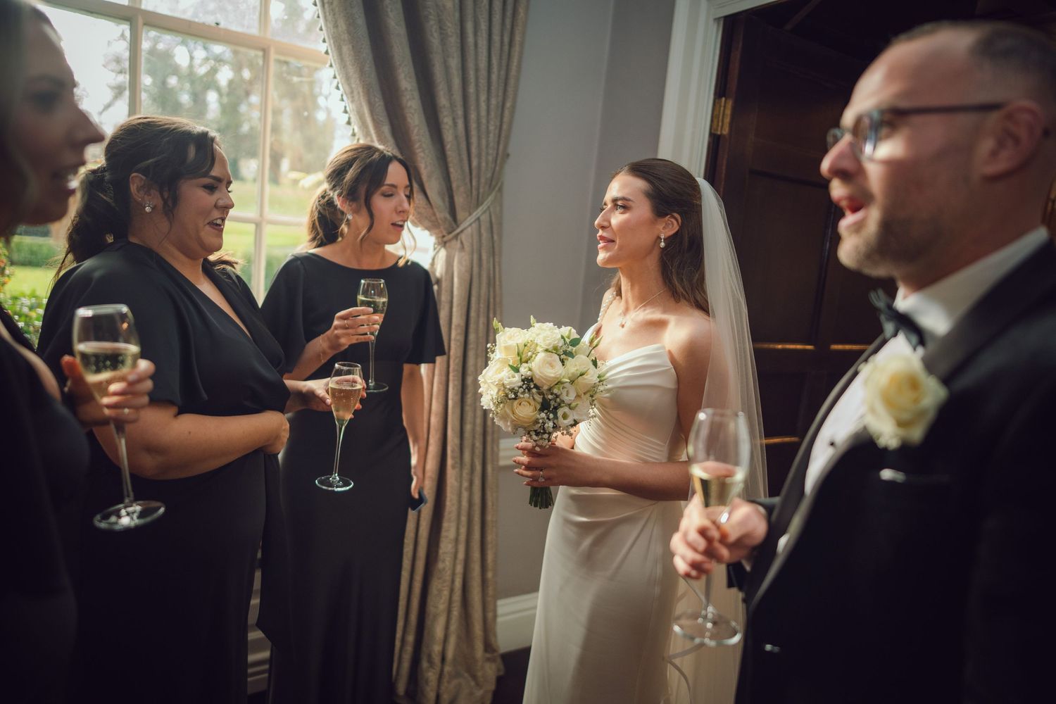 Bride in strapless white gown chats with bridesmaids at the Manor House Mount Juliet wedding Kilkenny.