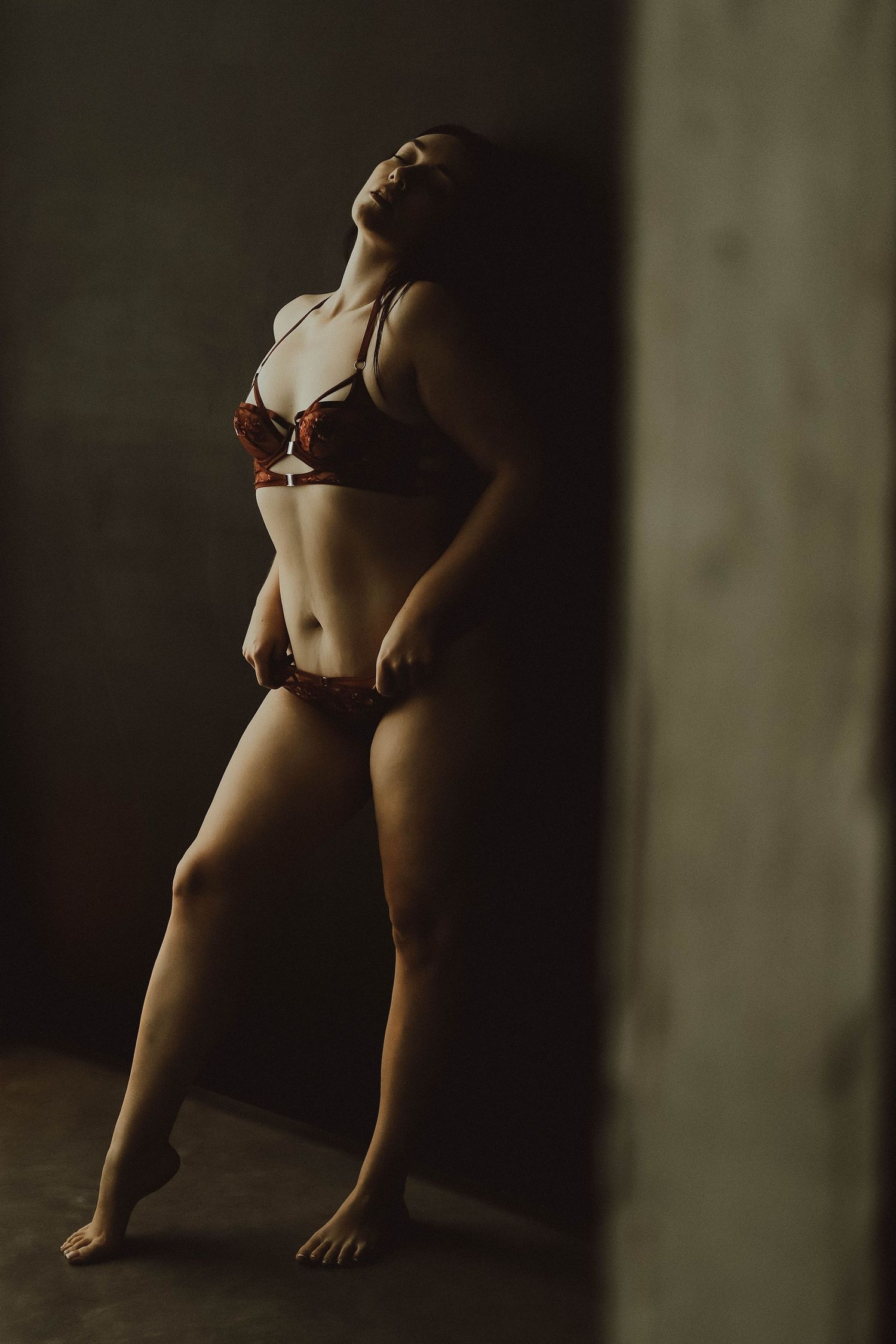 Artistic boudoir photography sequence showing silhouetted figure in dim lighting against dark background.