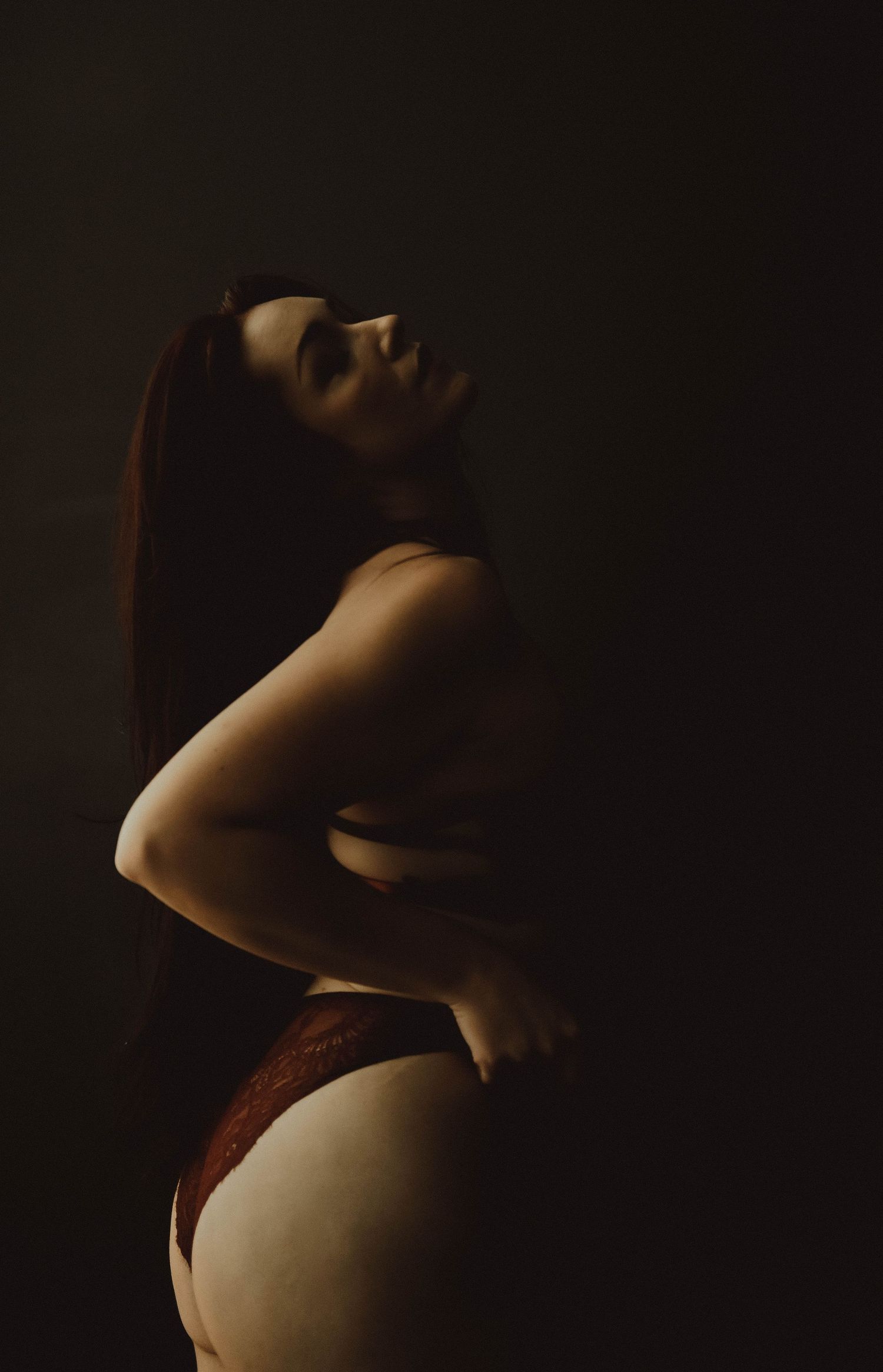 A series of artistic nude maternity photos showing a pregnant belly in dramatic shadows and lighting.