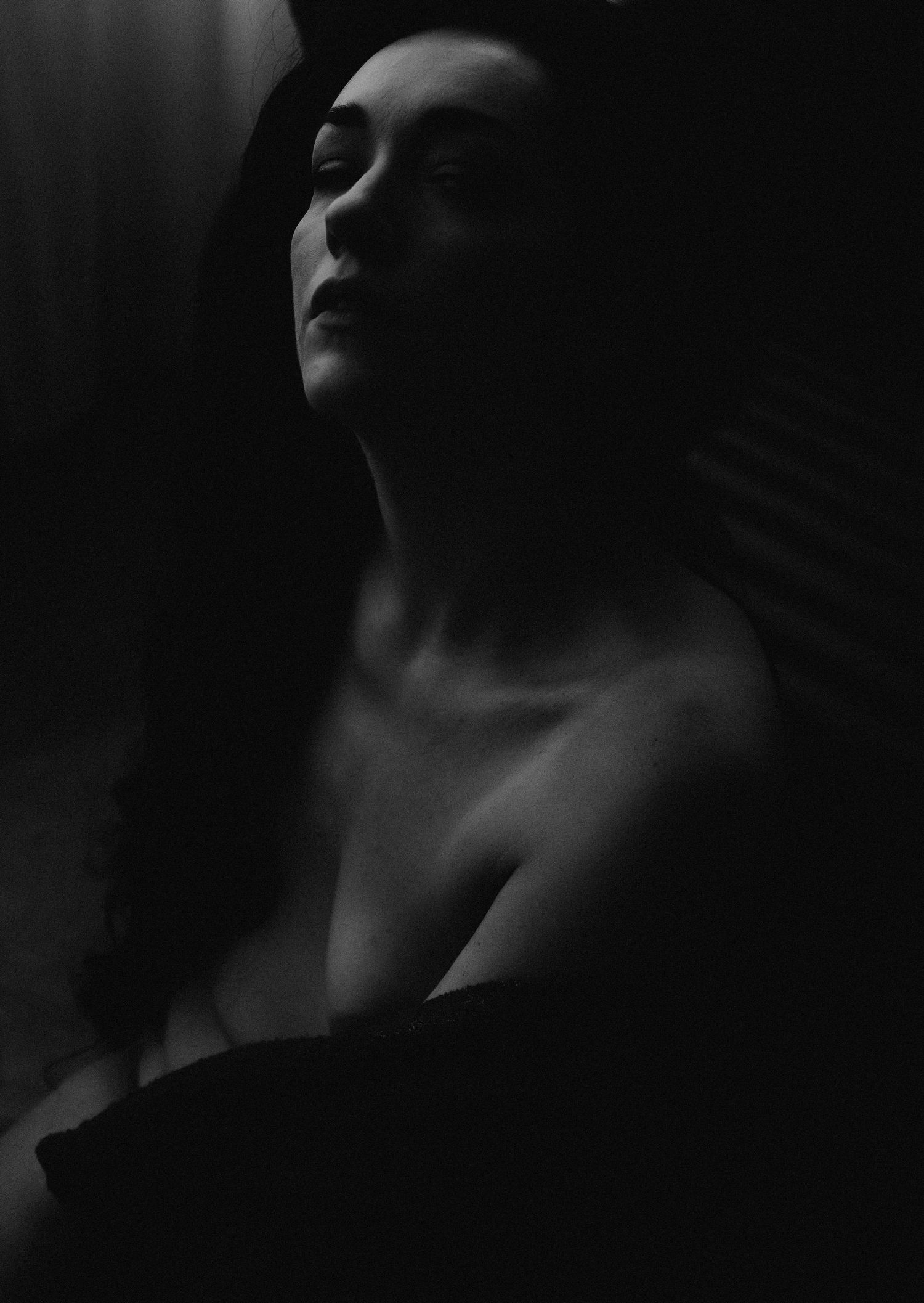 A dramatic black and white portrait series showing a person's neck and jawline in moody lighting.