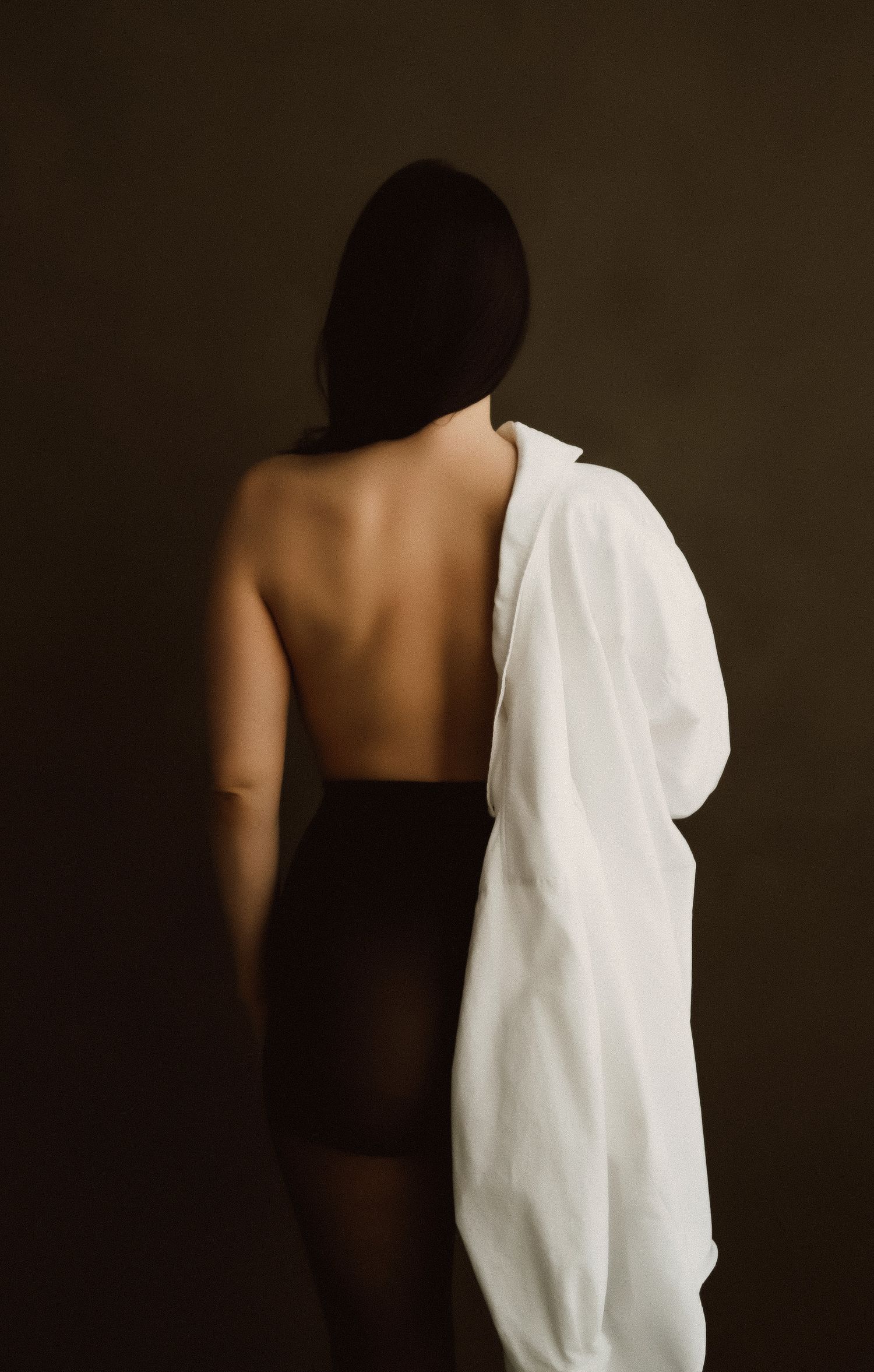 Artistic series of minimalist photographs showing a silhouetted figure against dark background with flowing white fabric.