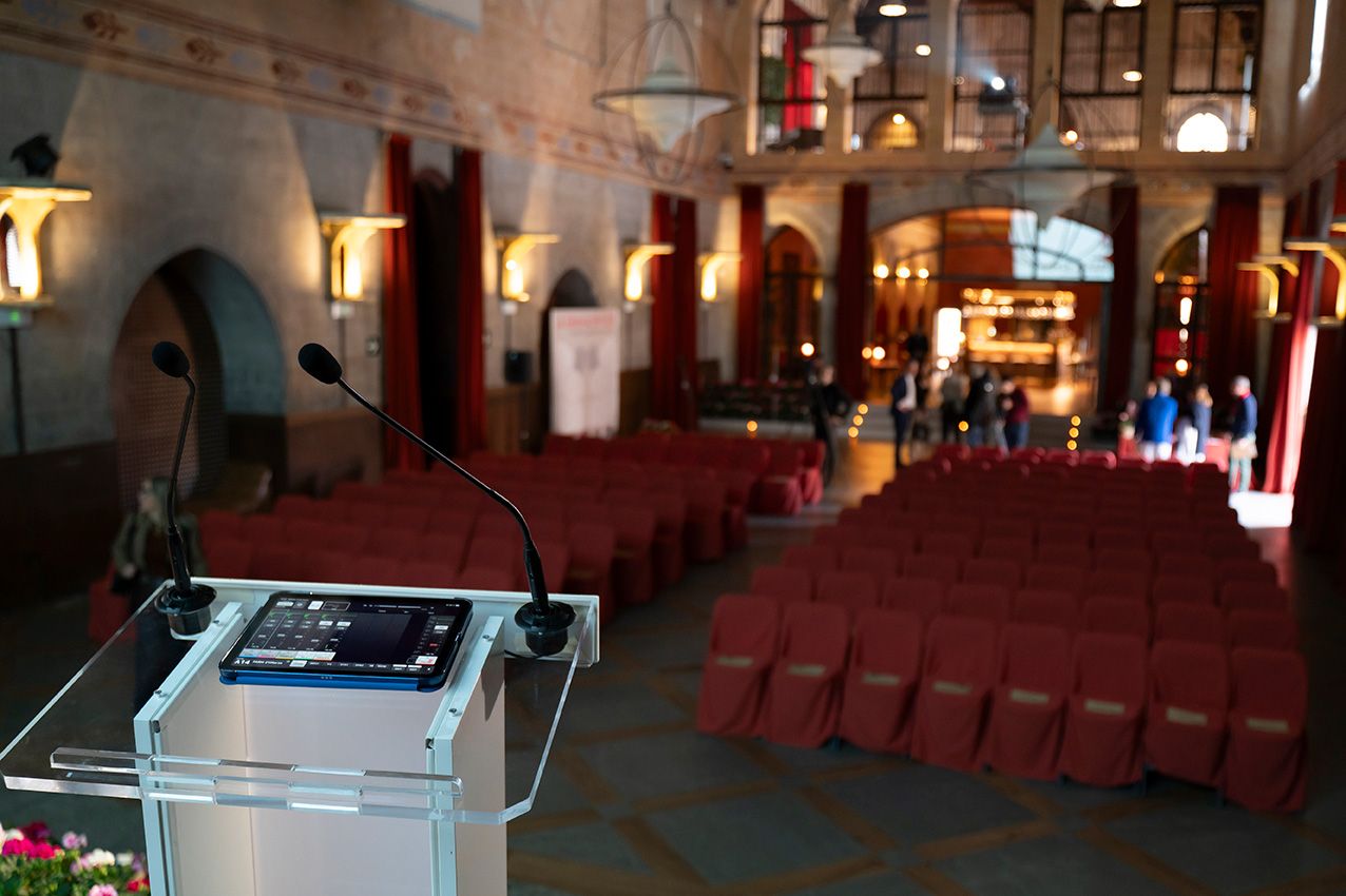 Empty auditorium with red seats and podium ready for La Granja en Flor spring event presentation.