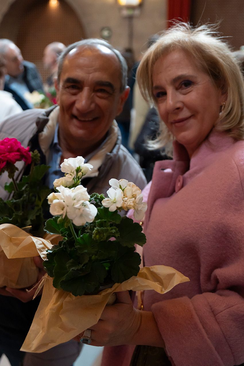 Smiling couple holding white and pink potted geraniums at La Granja en Flor event.