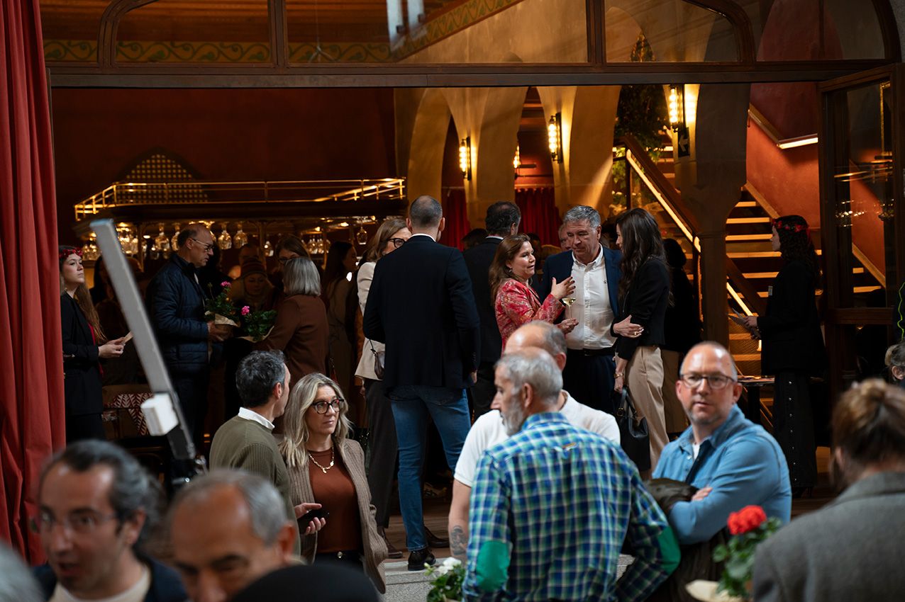 Guests mingling in elegant red-decorated venue during La Granja en Flor spring gathering.
