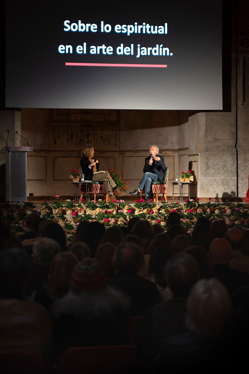 Two panelists discuss Sobre lo espiritual en el arte del jardin on stage before large audience.