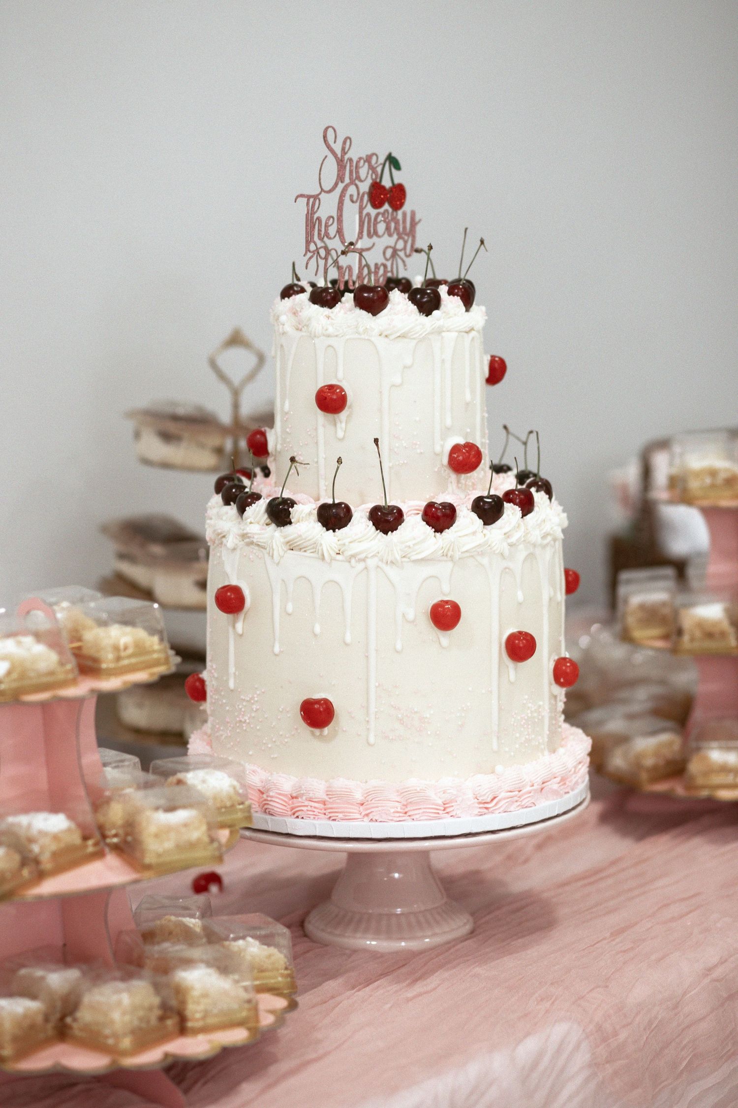 Two tier cake with topper on the pink dessert table at a miami baby shower. It's a girl!