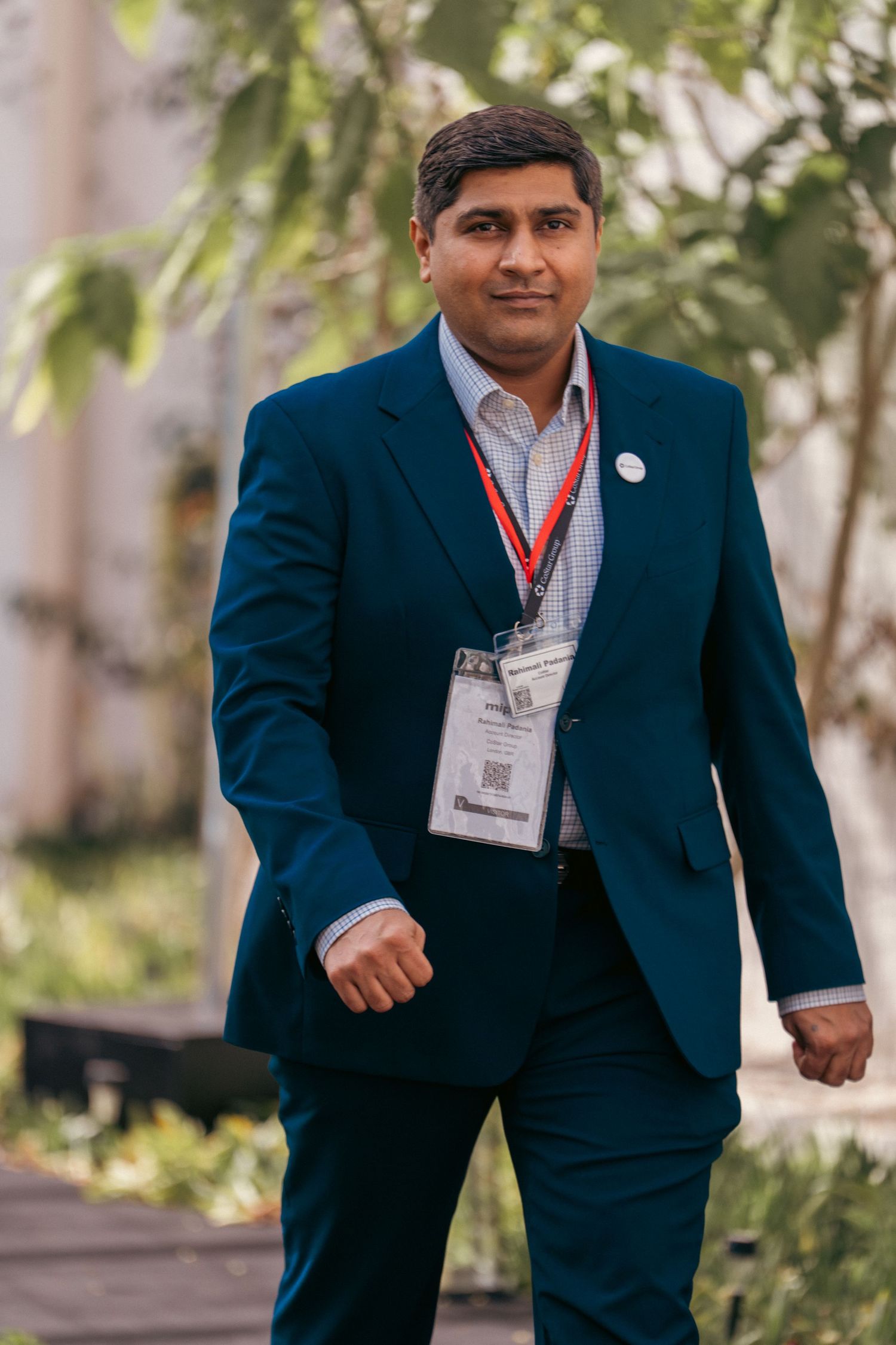 Professional attendees in navy suits with name badges at corporate function.