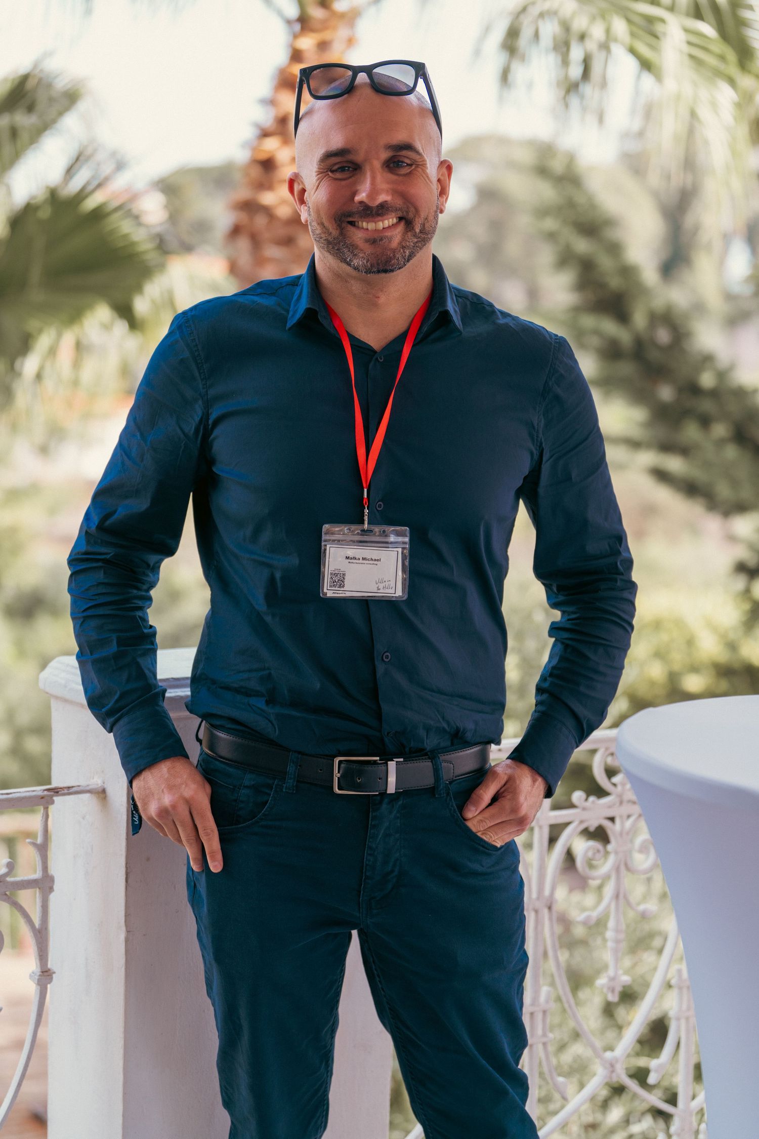 Professional wearing a navy blue outfit and name badge at an outdoor event.