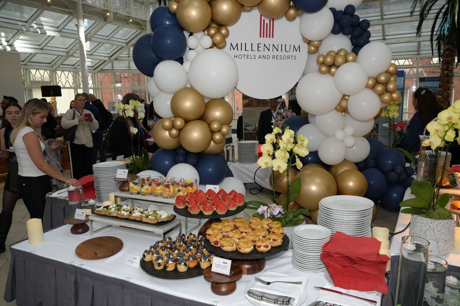 Millennium Hotels and Resorts branded balloon arch display with elegant food spread at a catering event.