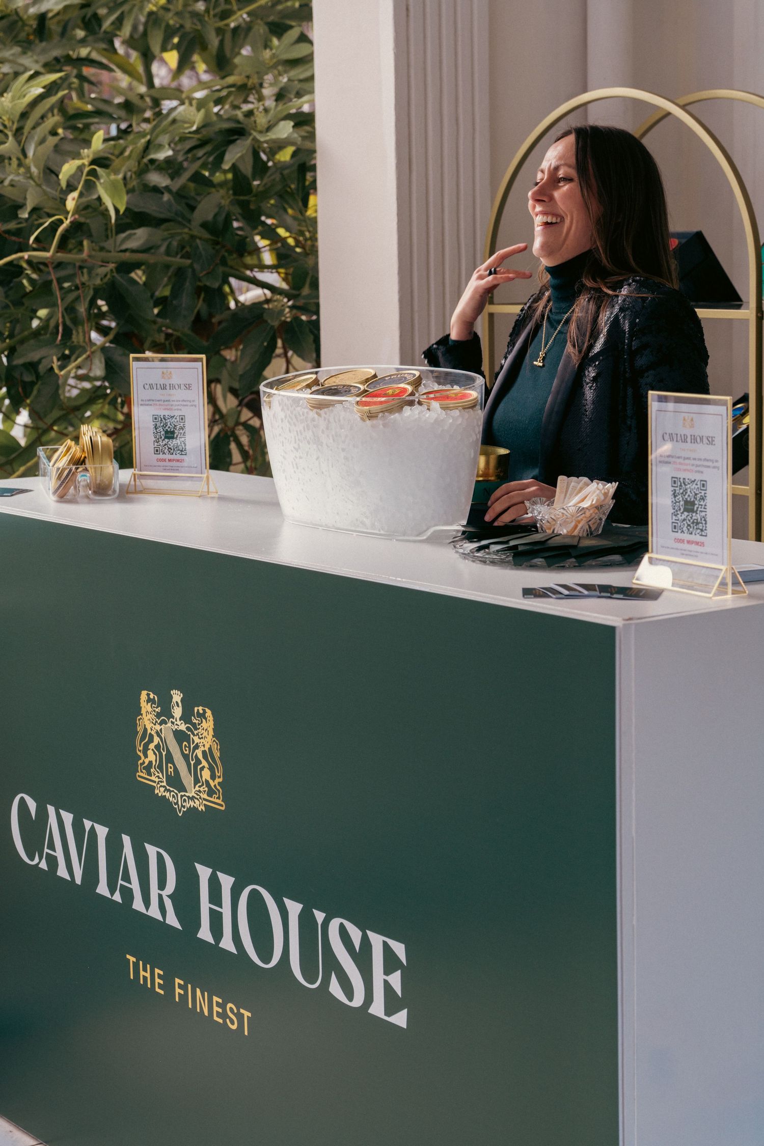Luxury caviar service counter with green branded signage and elegant decor.