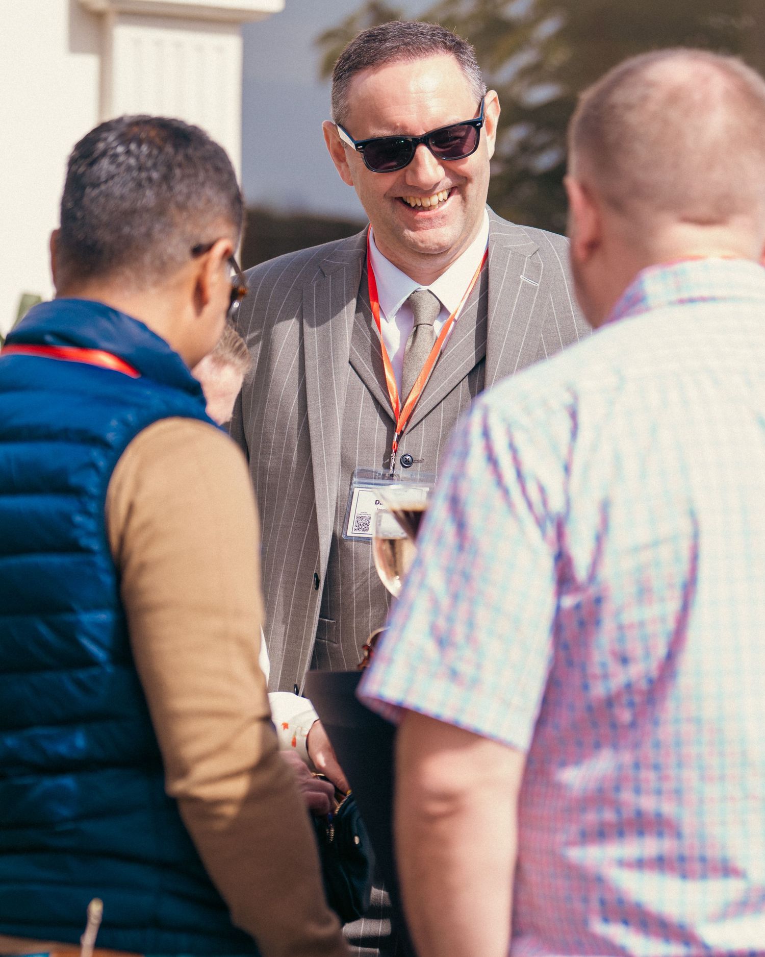 Business professionals engaged in conversation at outdoor networking event.