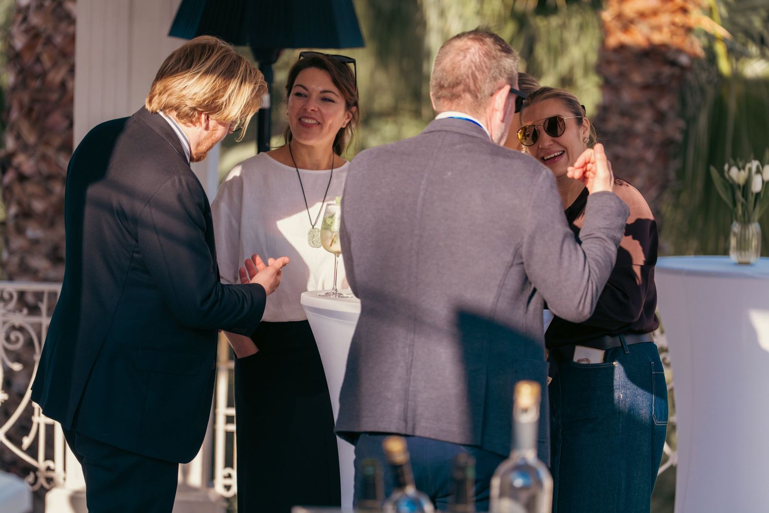 Group of attendees networking and conversing at an outdoor social function.