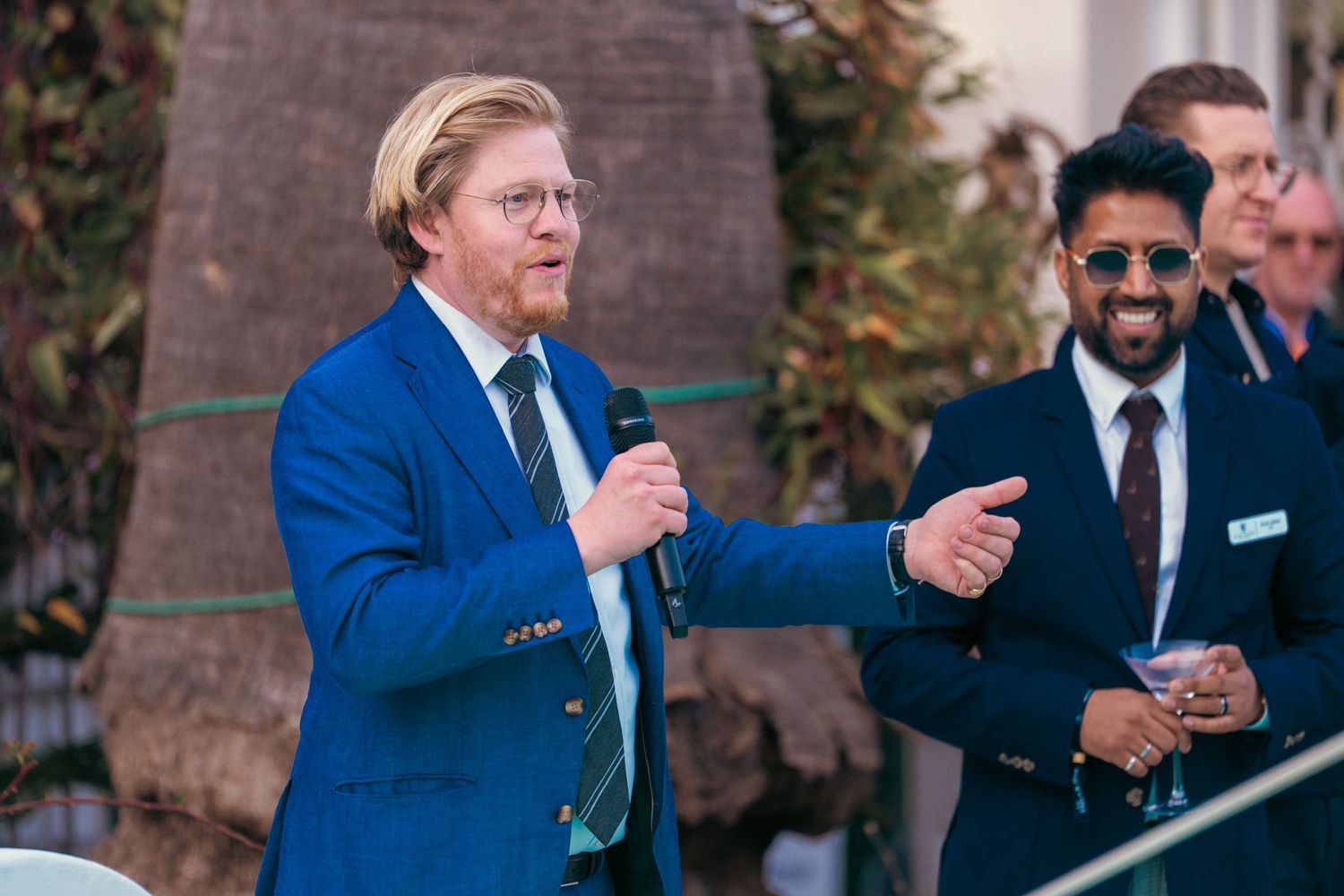People in business attire gather at an outdoor networking event.