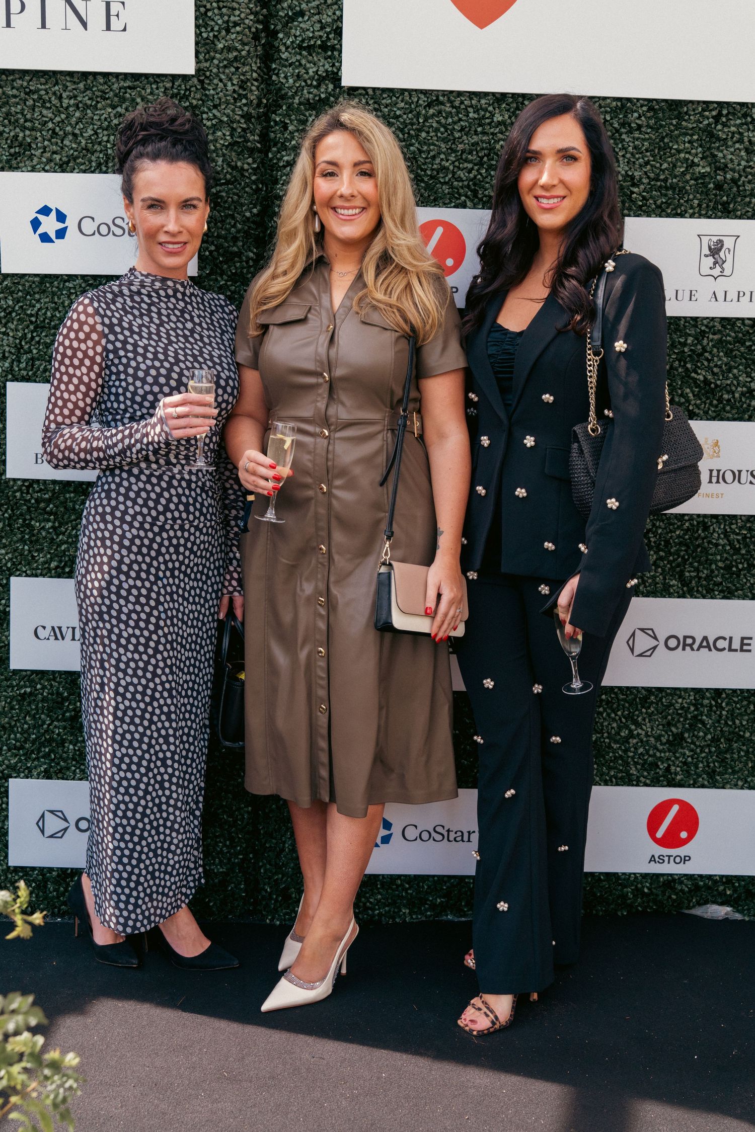 Group of attendees posing at a corporate event with branded backdrop.