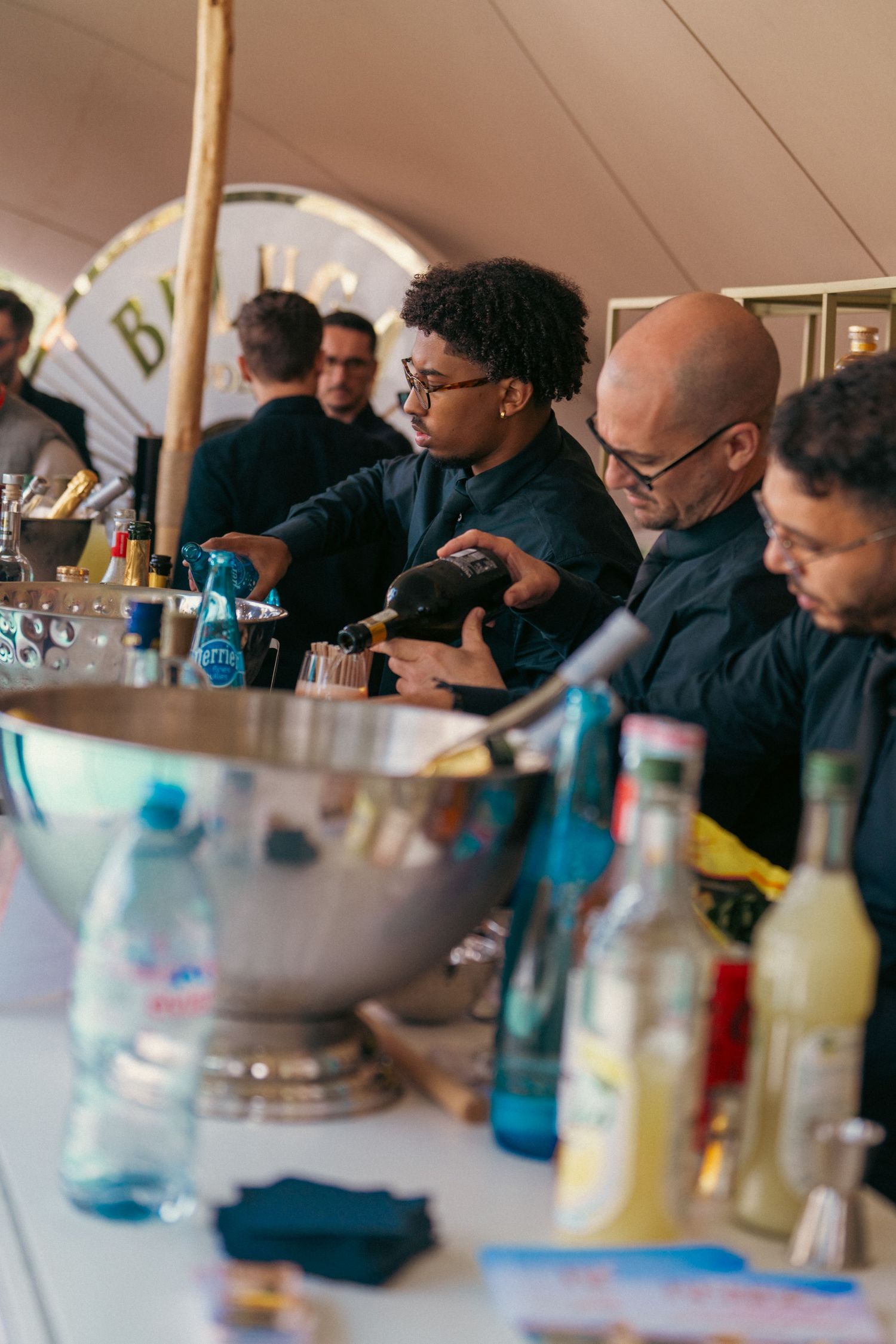 Business professionals seated at a table during a conference or meeting with drinks and refreshments.