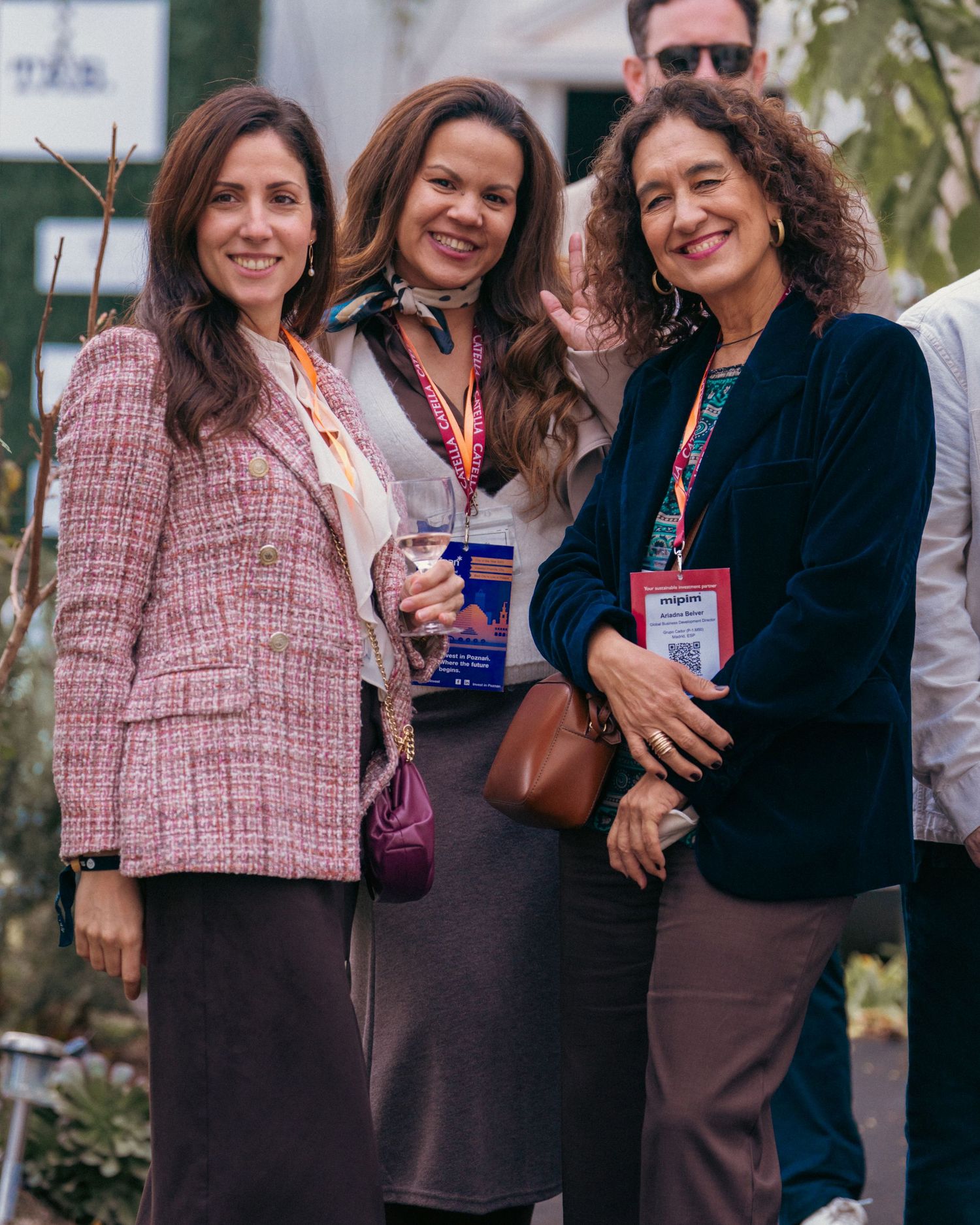 A group of attendees in business attire pose together at an outdoor conference.